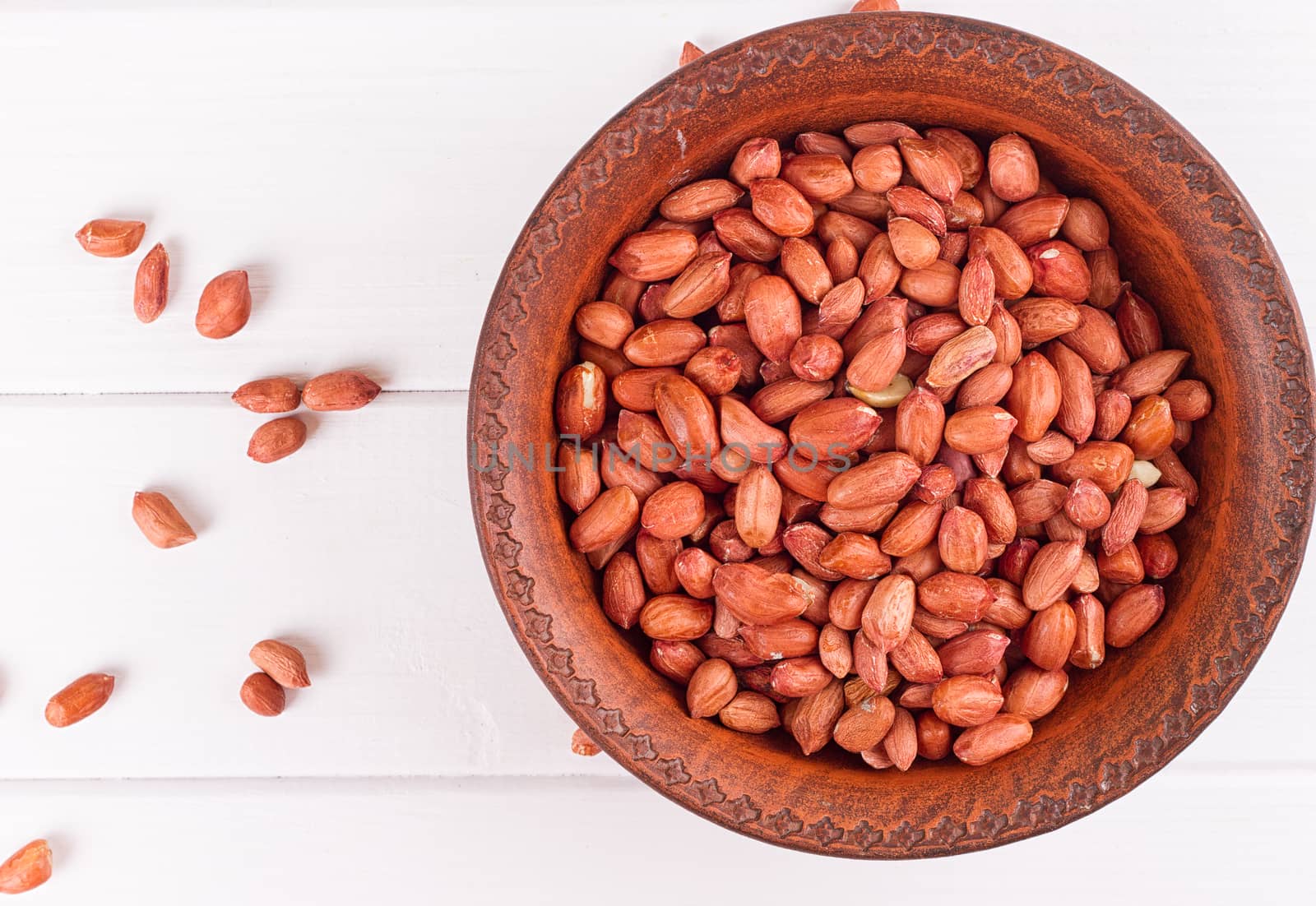 Peanuts in a brown plate. on white background