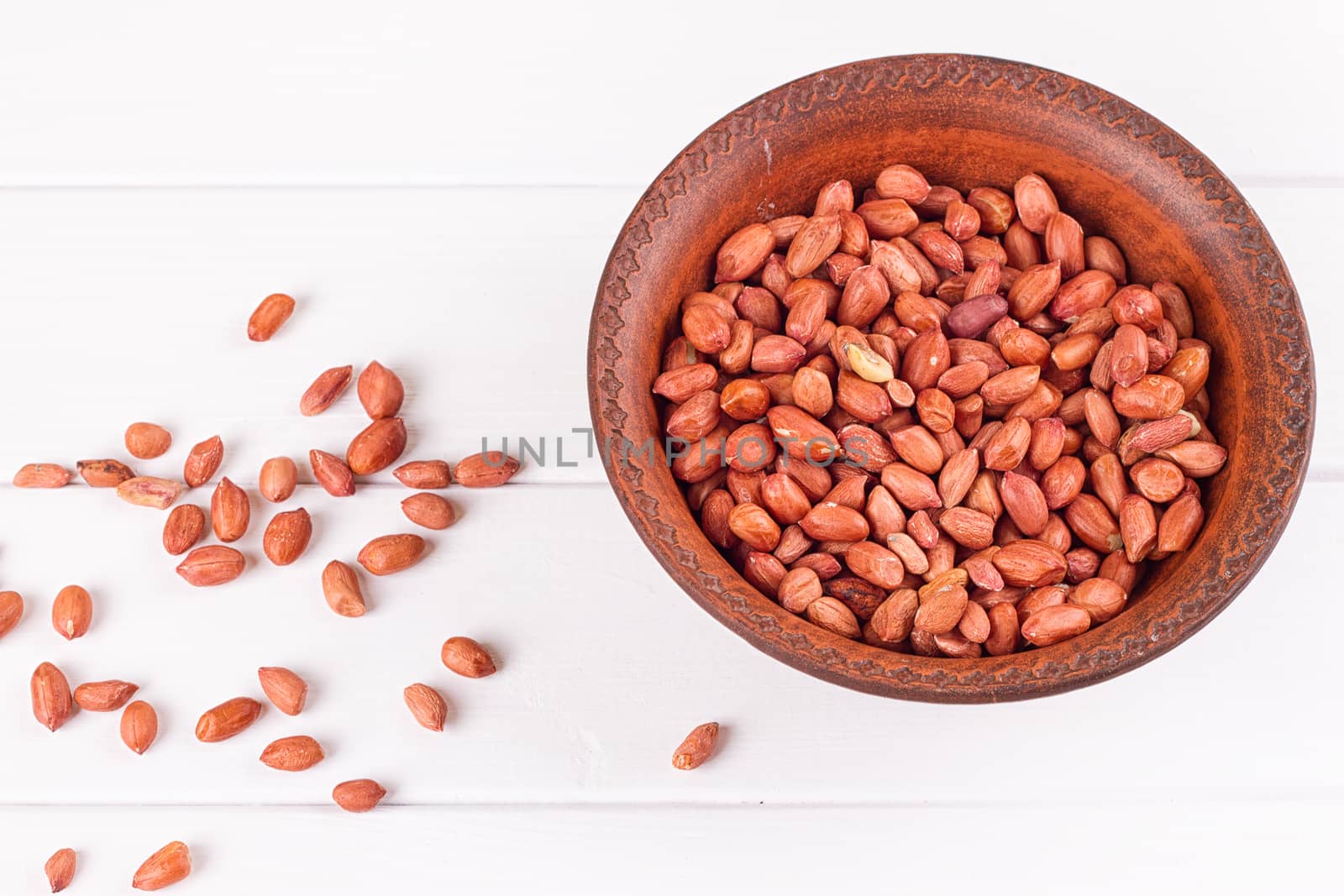 Peanuts in a brown plate. on white background