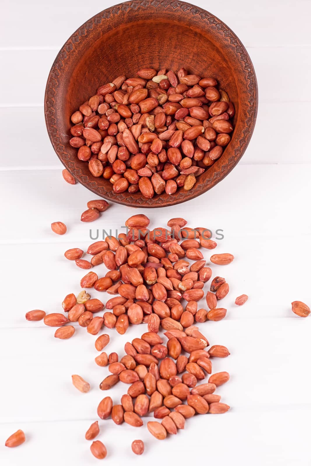 Peanuts in a brown plate. on white background