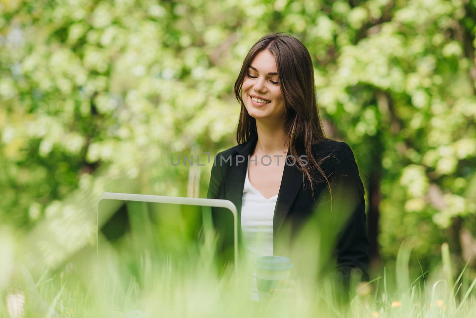 Beautiful business woman in suit using laptop computer in the park