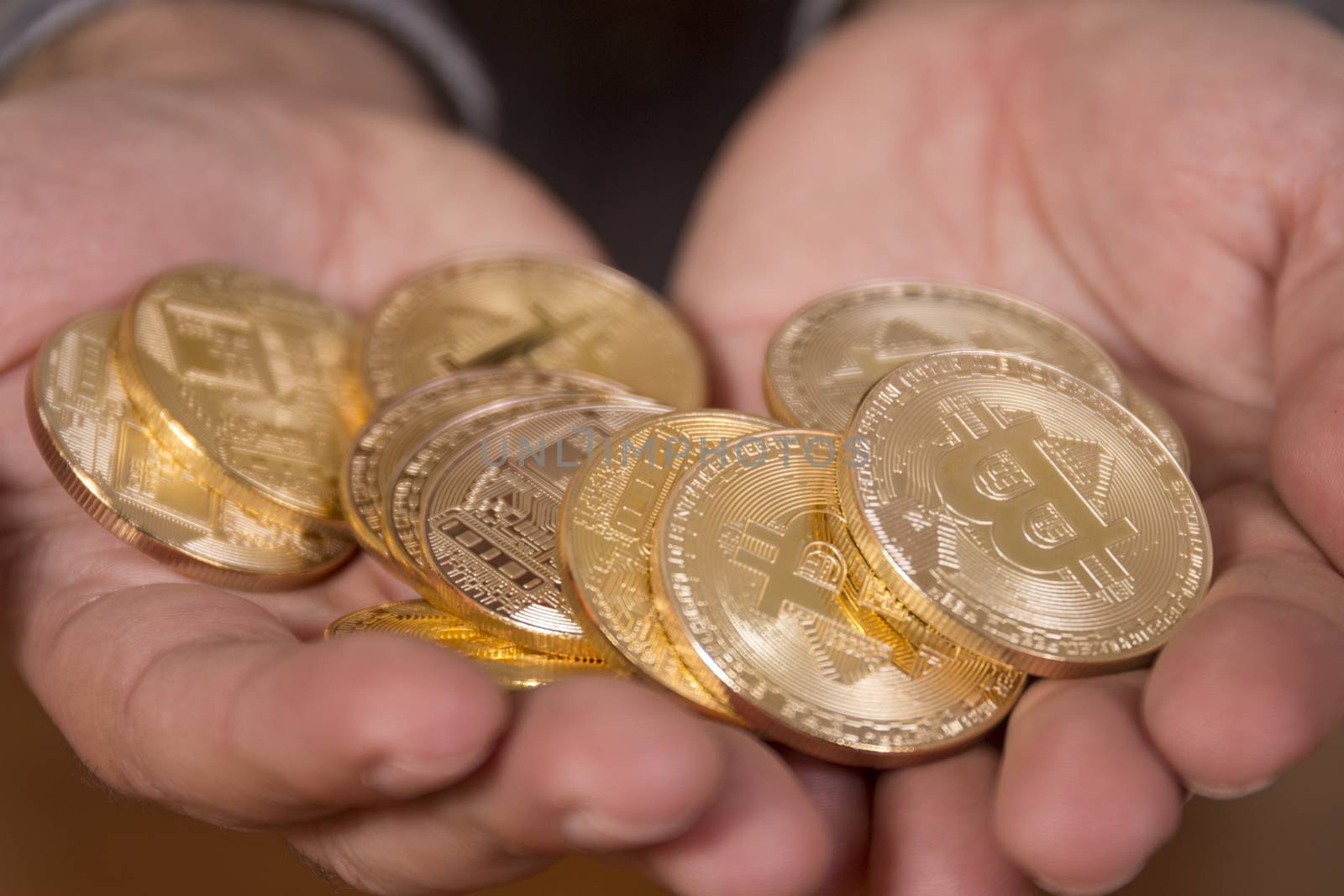 hand holding a bunch of  bitcoins, a digital crypto currency.