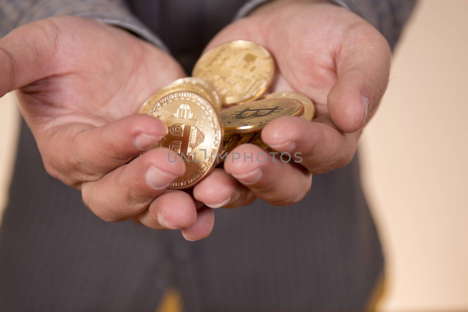 hand holding a bunch of  bitcoins, a digital crypto currency.