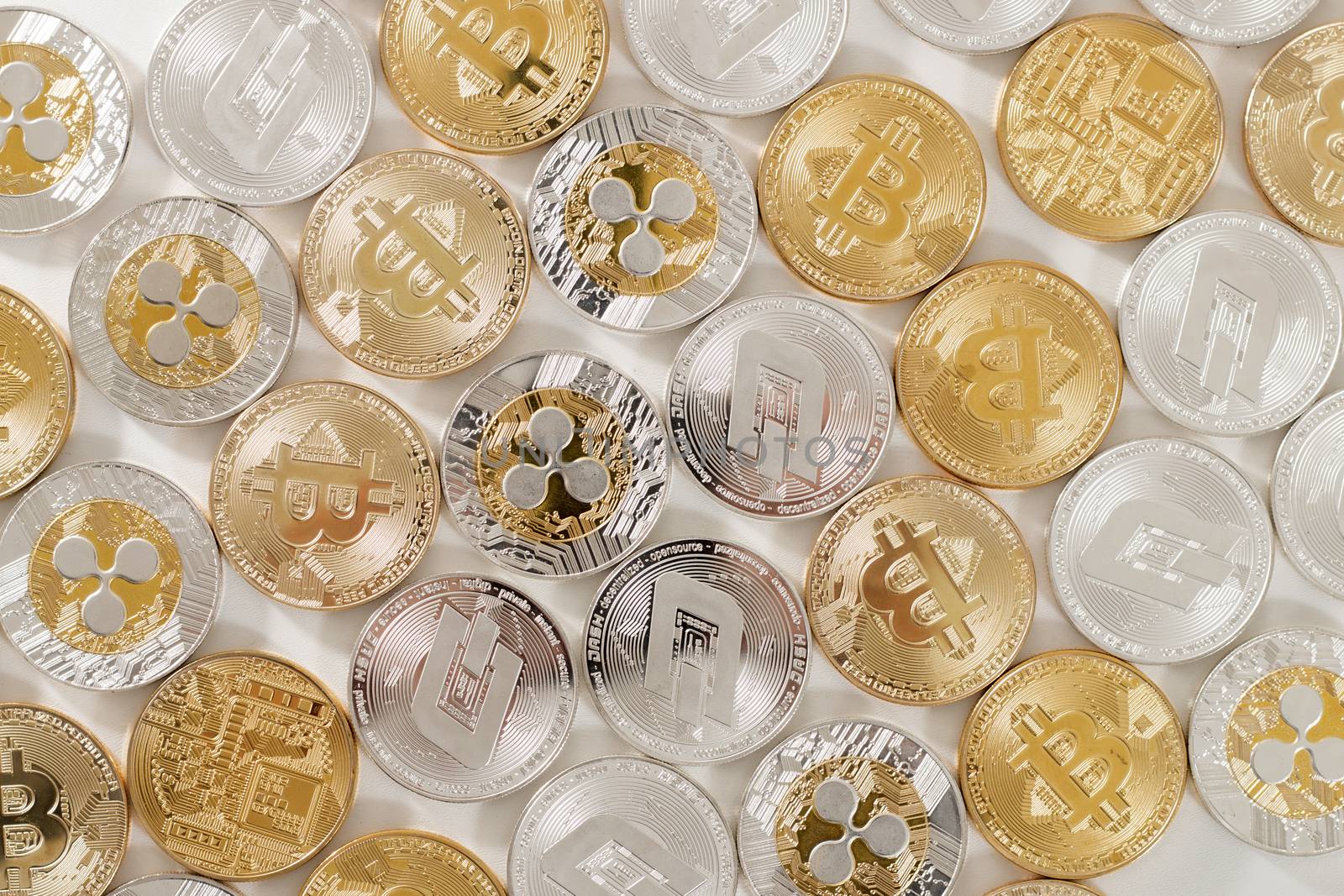 several aligned crypto currency coins on a white background.