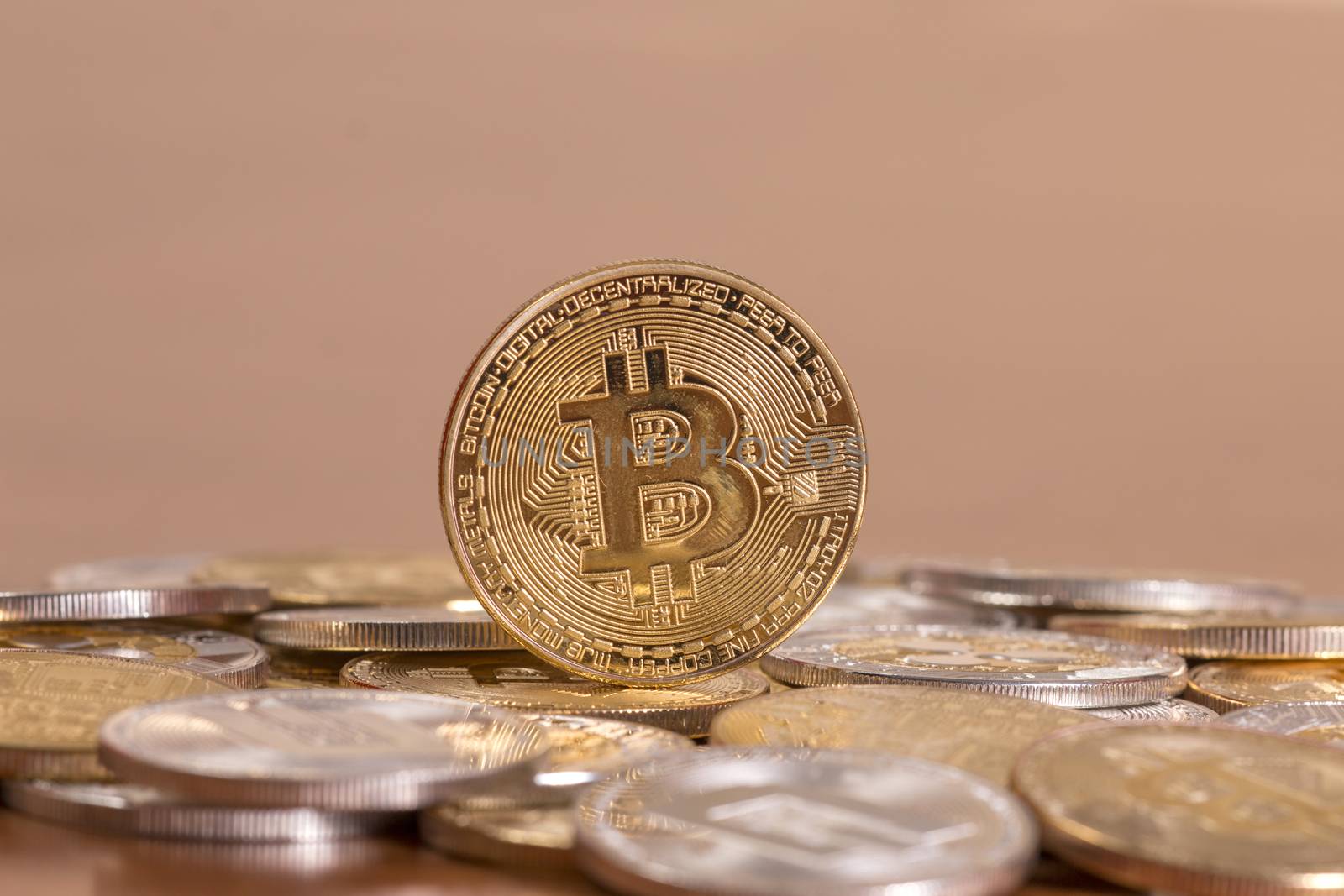 several aligned crypto currency coins on top of wooden table.