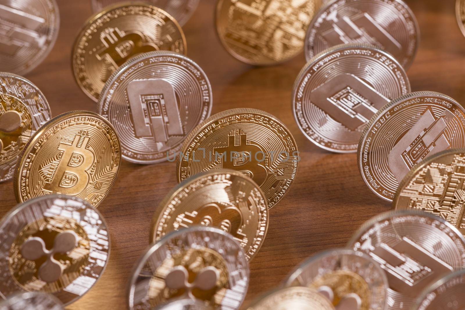 several aligned crypto currency coins on top of wooden table.