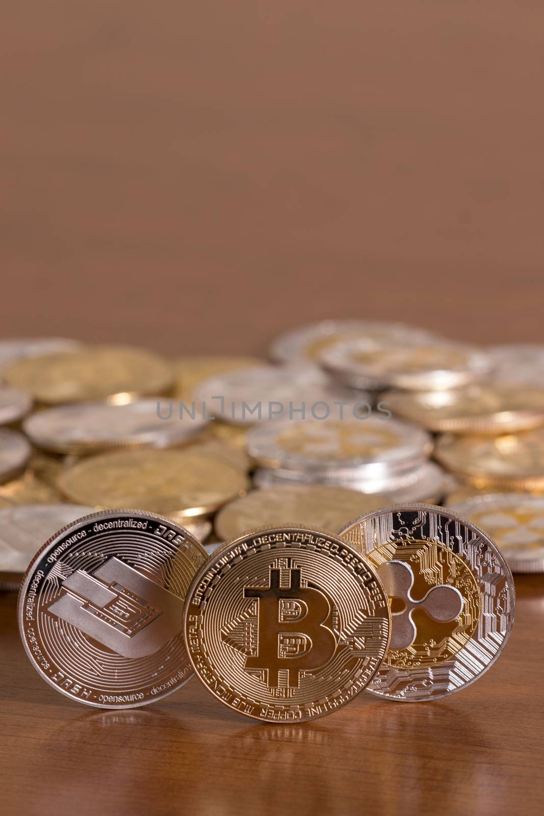 several aligned crypto currency coins on top of wooden table.