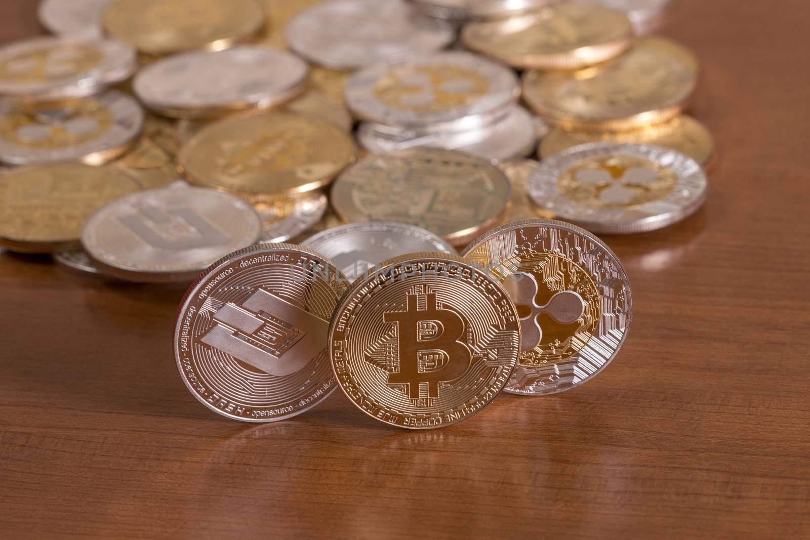 several aligned crypto currency coins on top of wooden table.