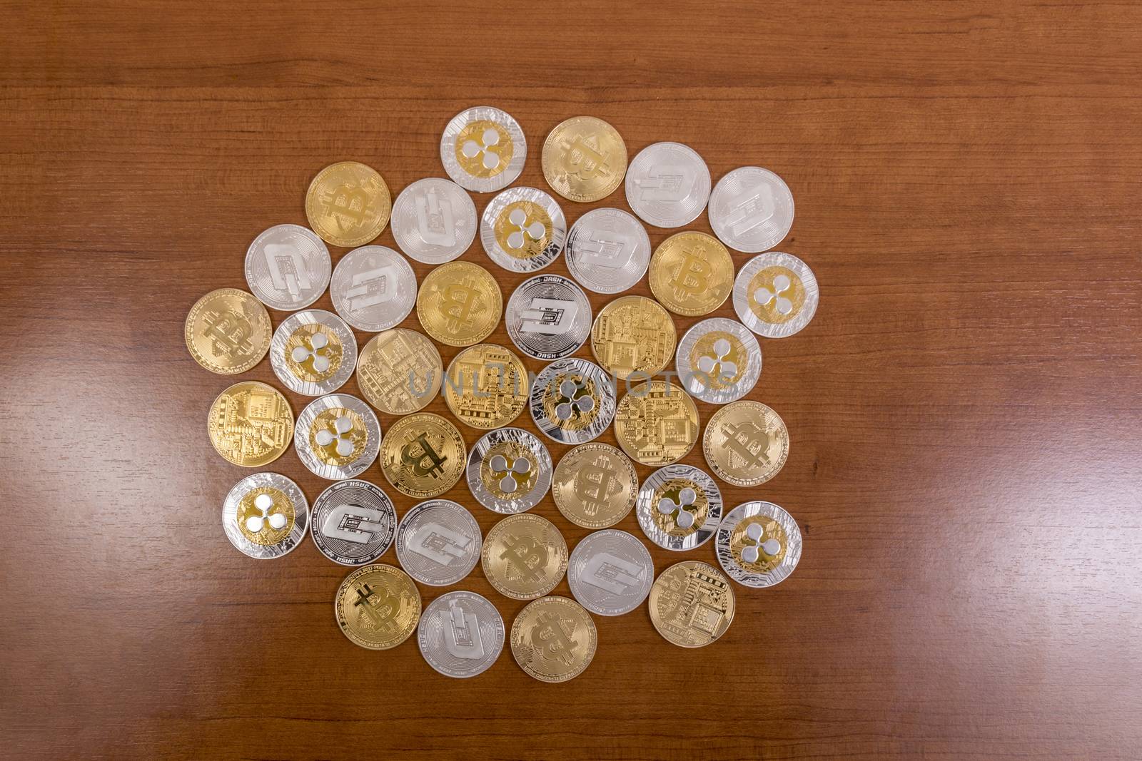 several aligned crypto currency coins on top of wooden table.