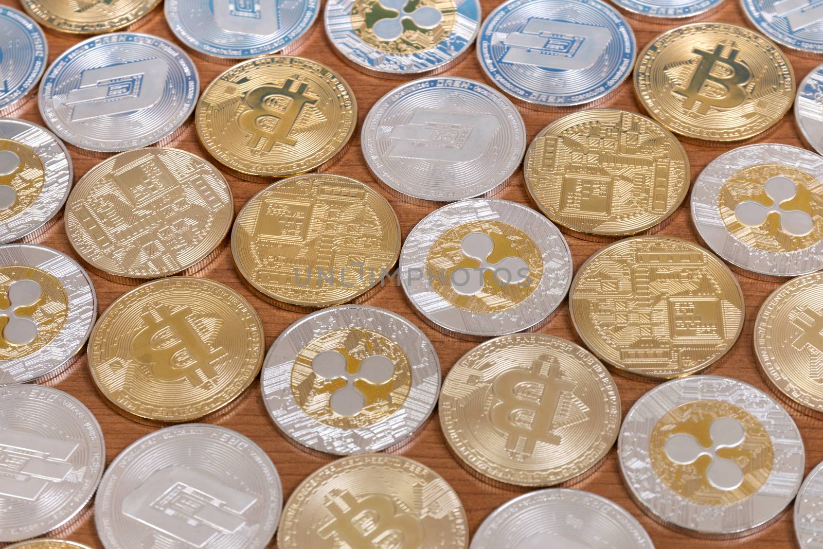 several aligned crypto currency coins on top of wooden table.