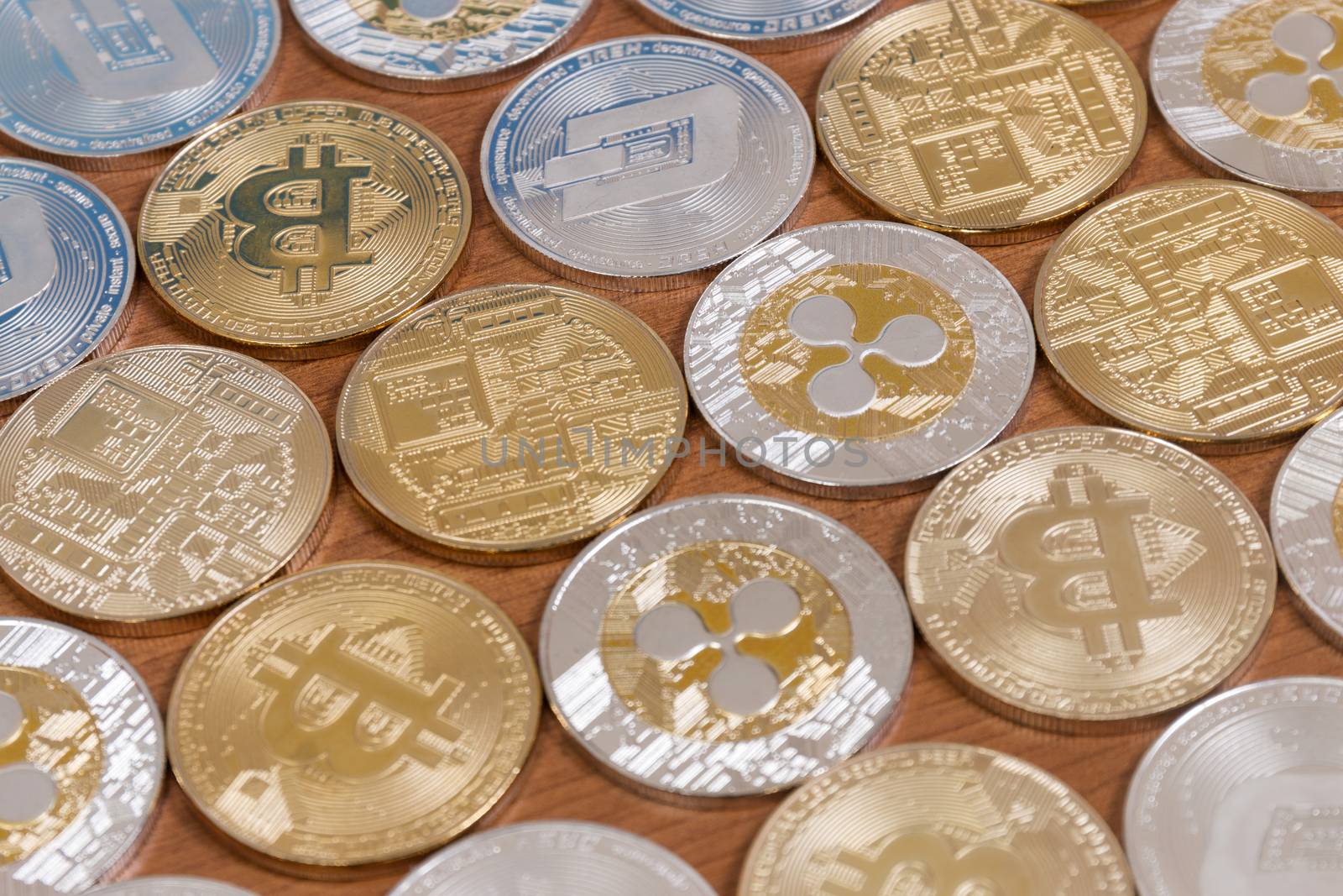 several aligned crypto currency coins on top of wooden table.