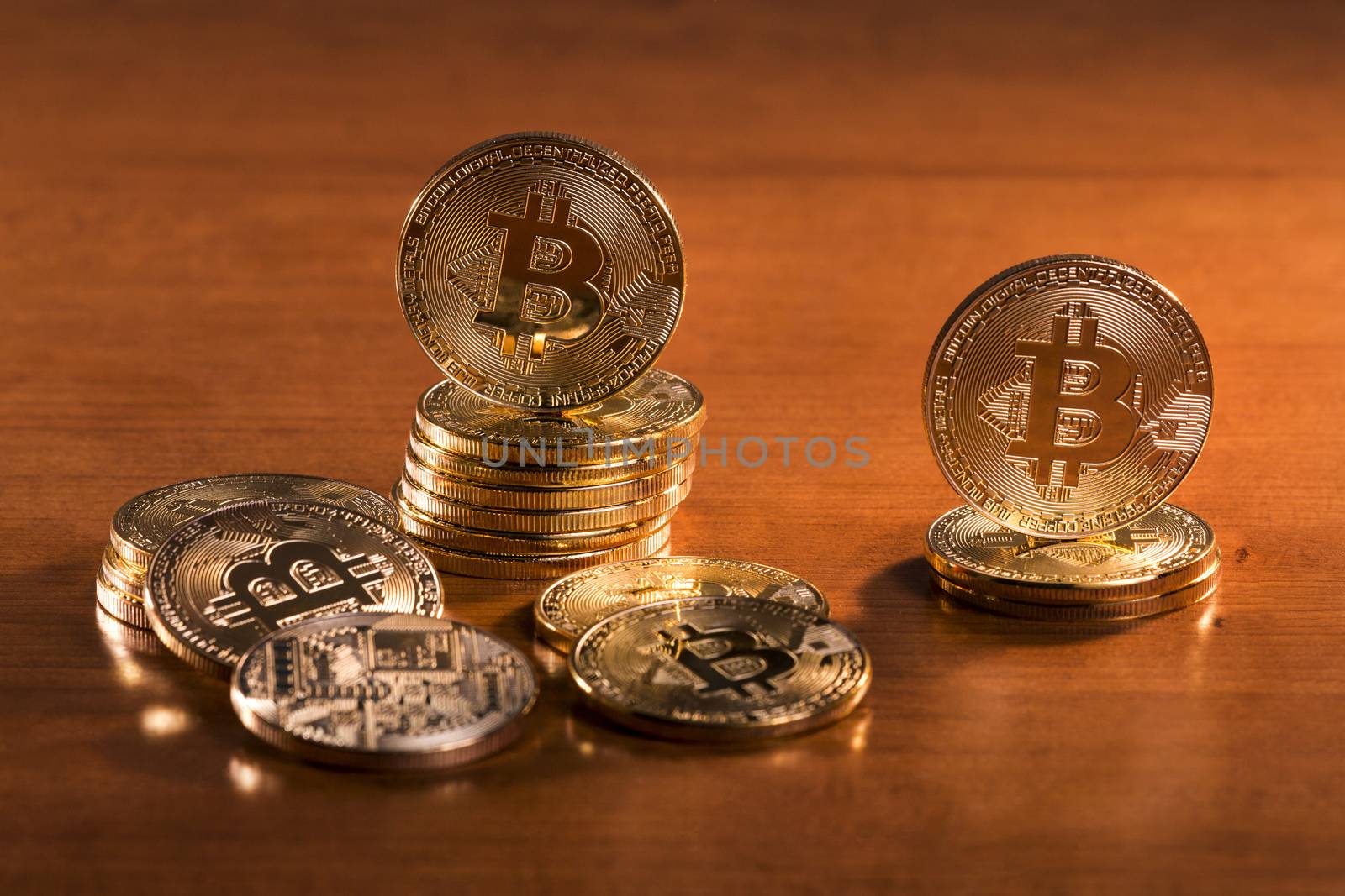 several golden bitcoins on top of wooden table.