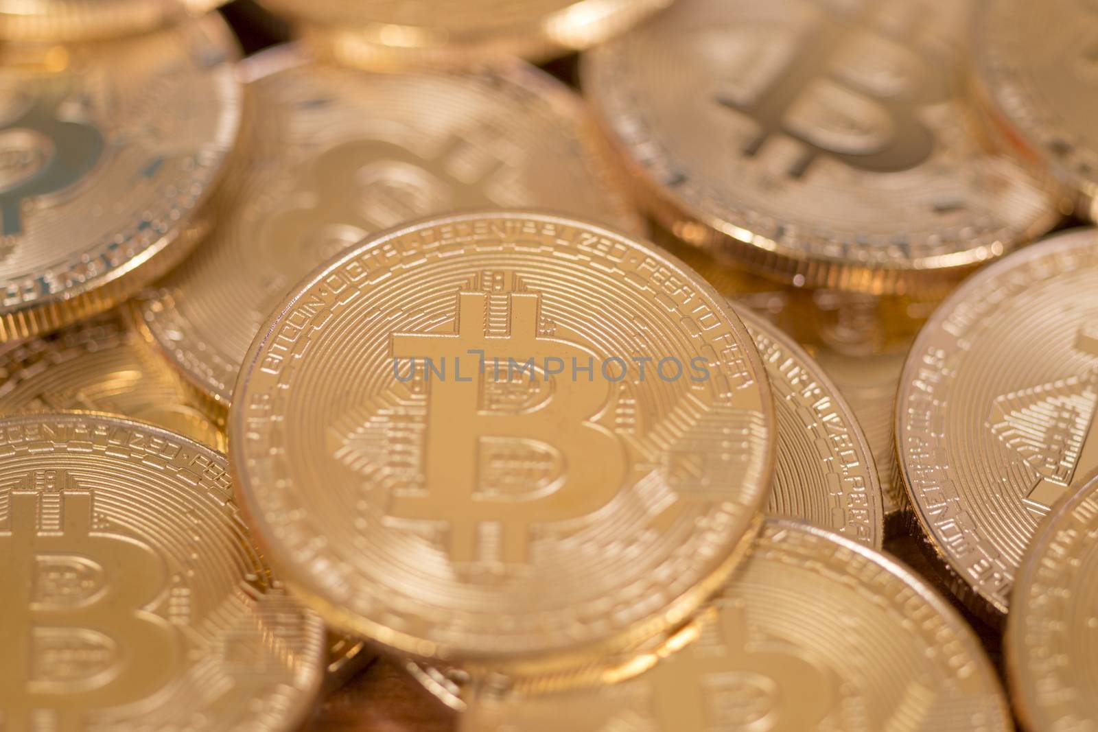 several golden bitcoins on top of wooden table.