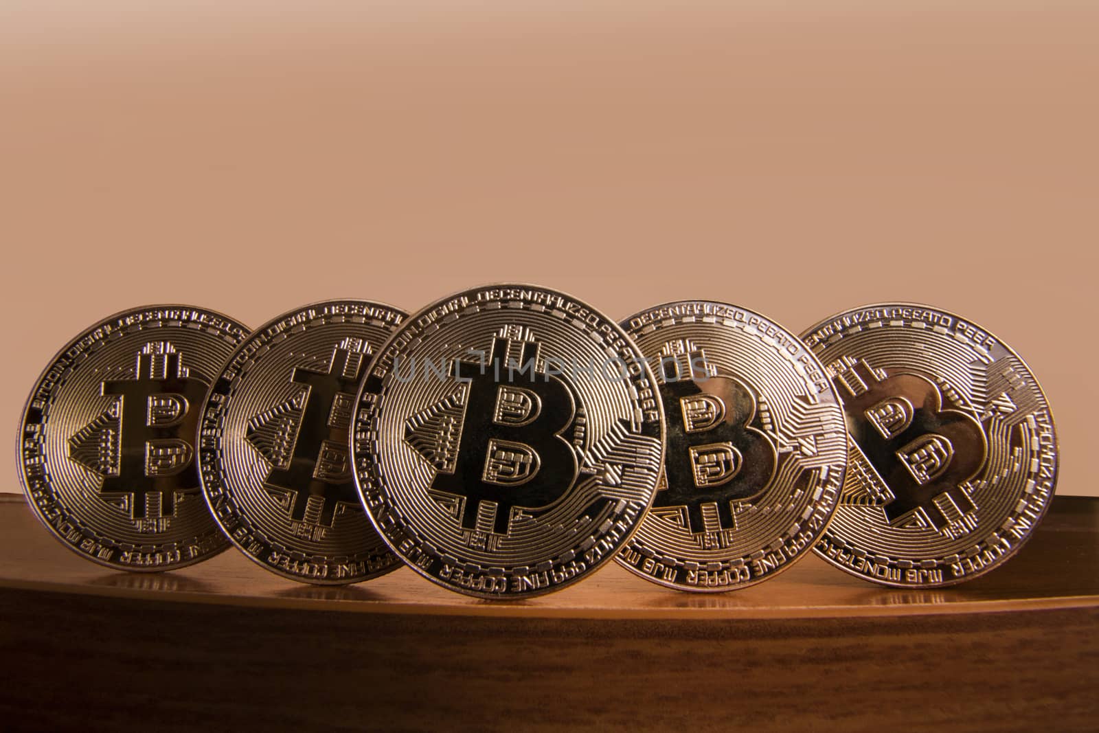 Shiny golden bitcoins on top of wooden table.