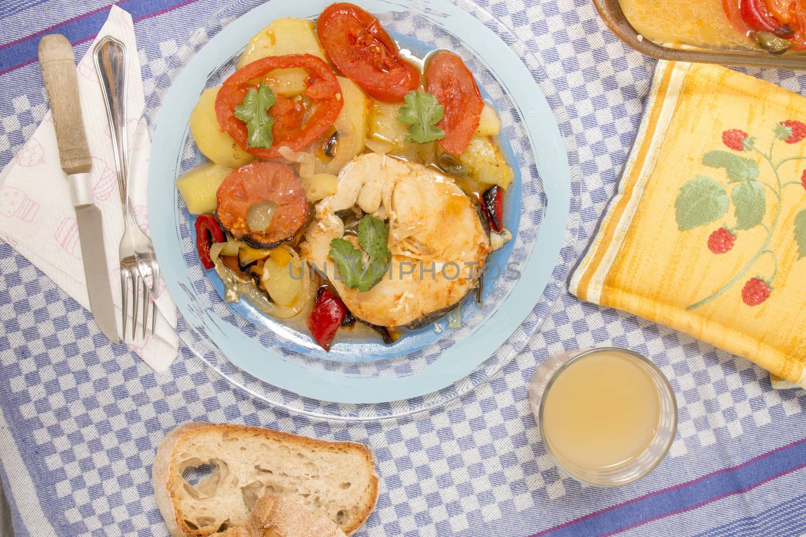 Traditional portuguese meal of fish with potatoes and tomato, made on the oven.