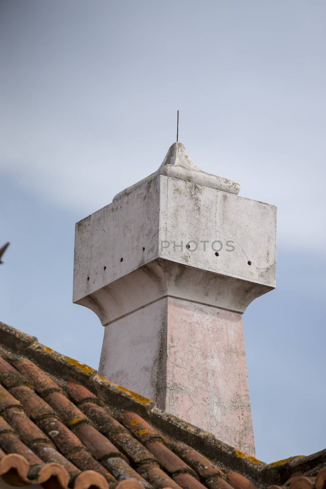 Typical chimneys on red tile roofs in Portuguese architecture.