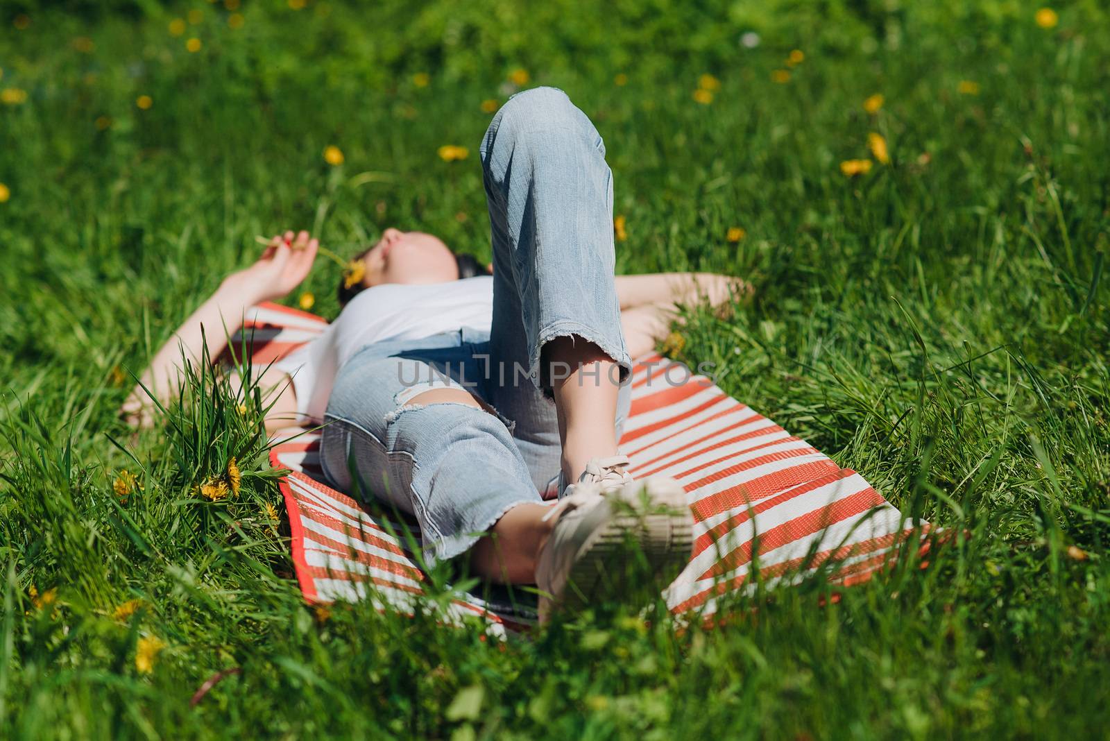 Woman laying on grass in park by ALotOfPeople