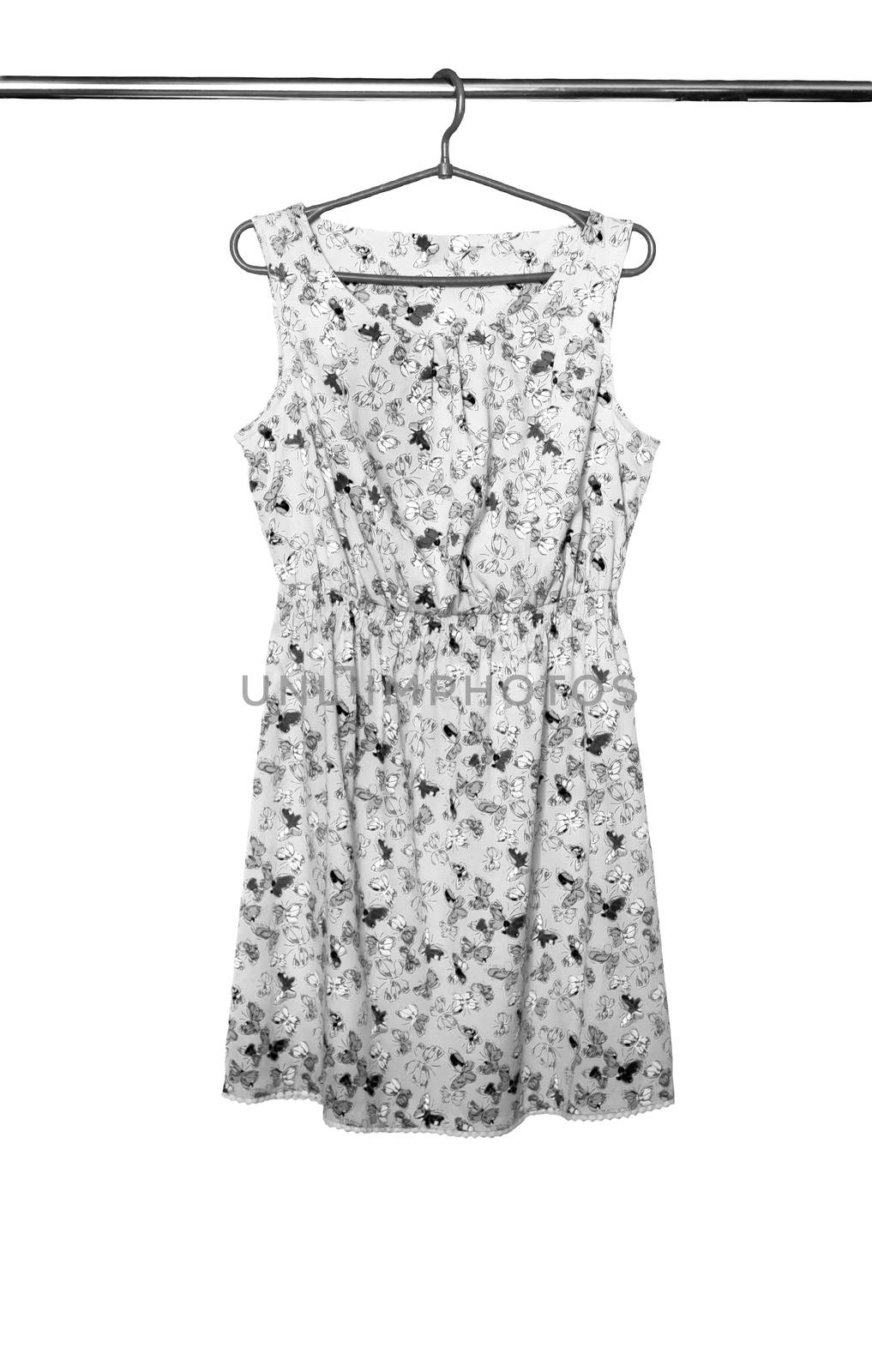 Summer dress with a butterfly pattern hanging on a hanger, isolated.