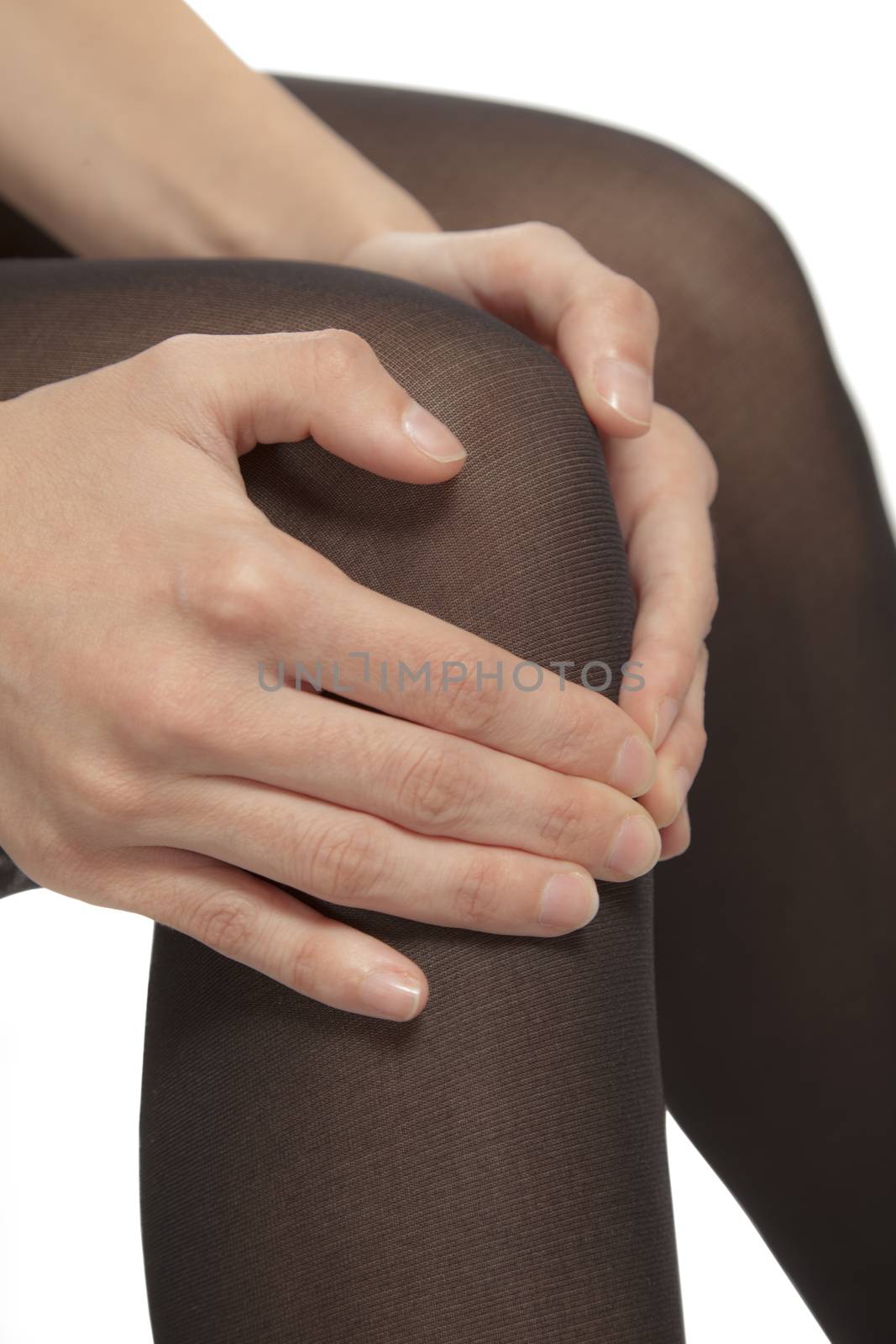 Close-up of female legs with pantyhose. Woman is rubbing her knee to relax pain.