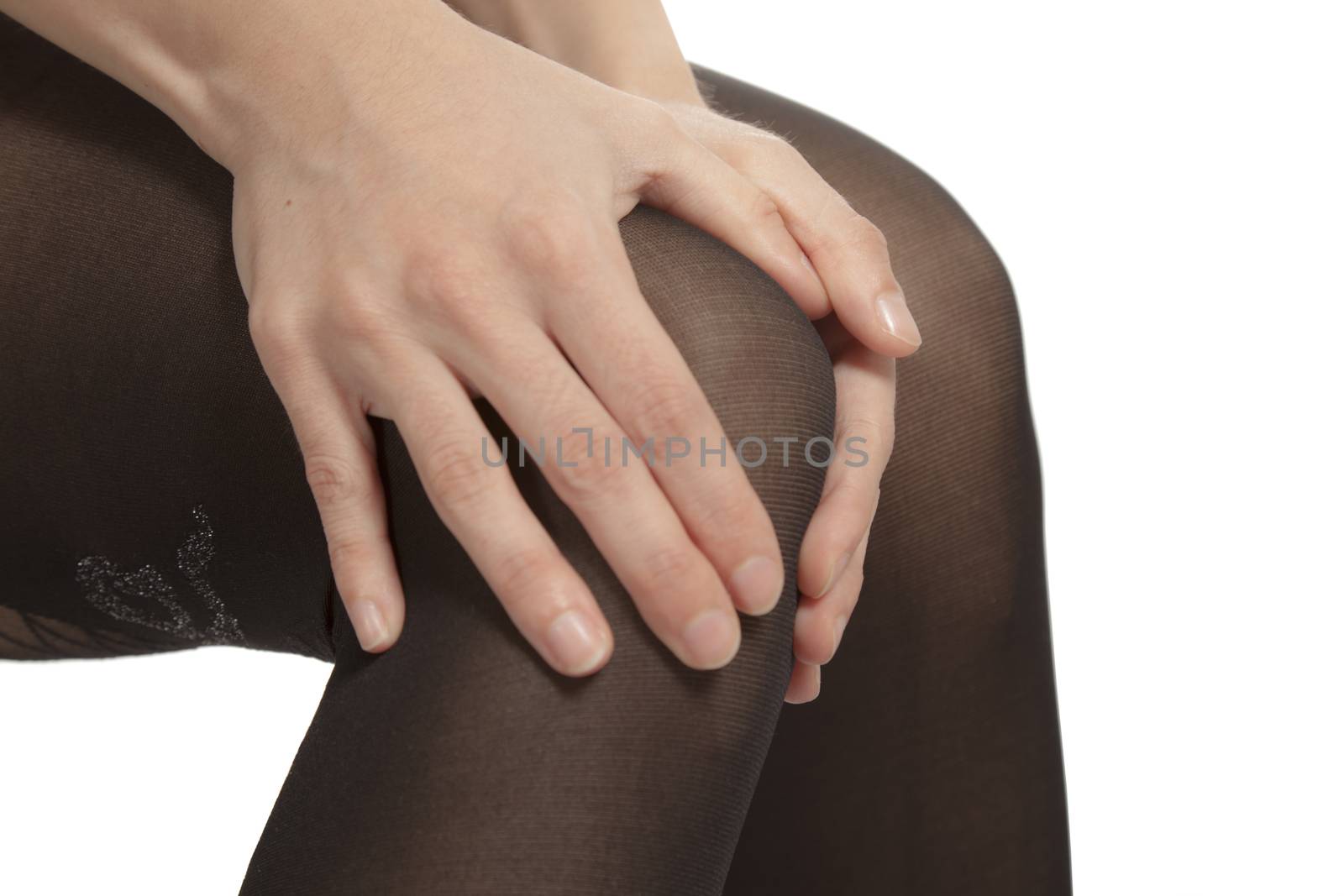 Close-up of female legs with pantyhose. Woman is rubbing her knee to relax pain.