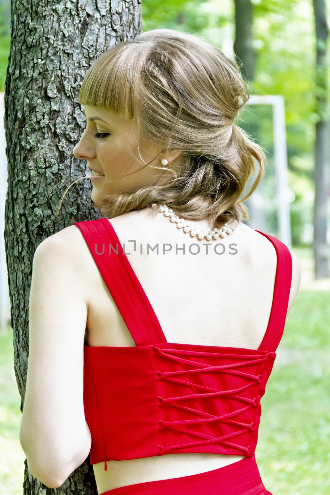 Portrait of beautiful girl with white pearl earring near tree
