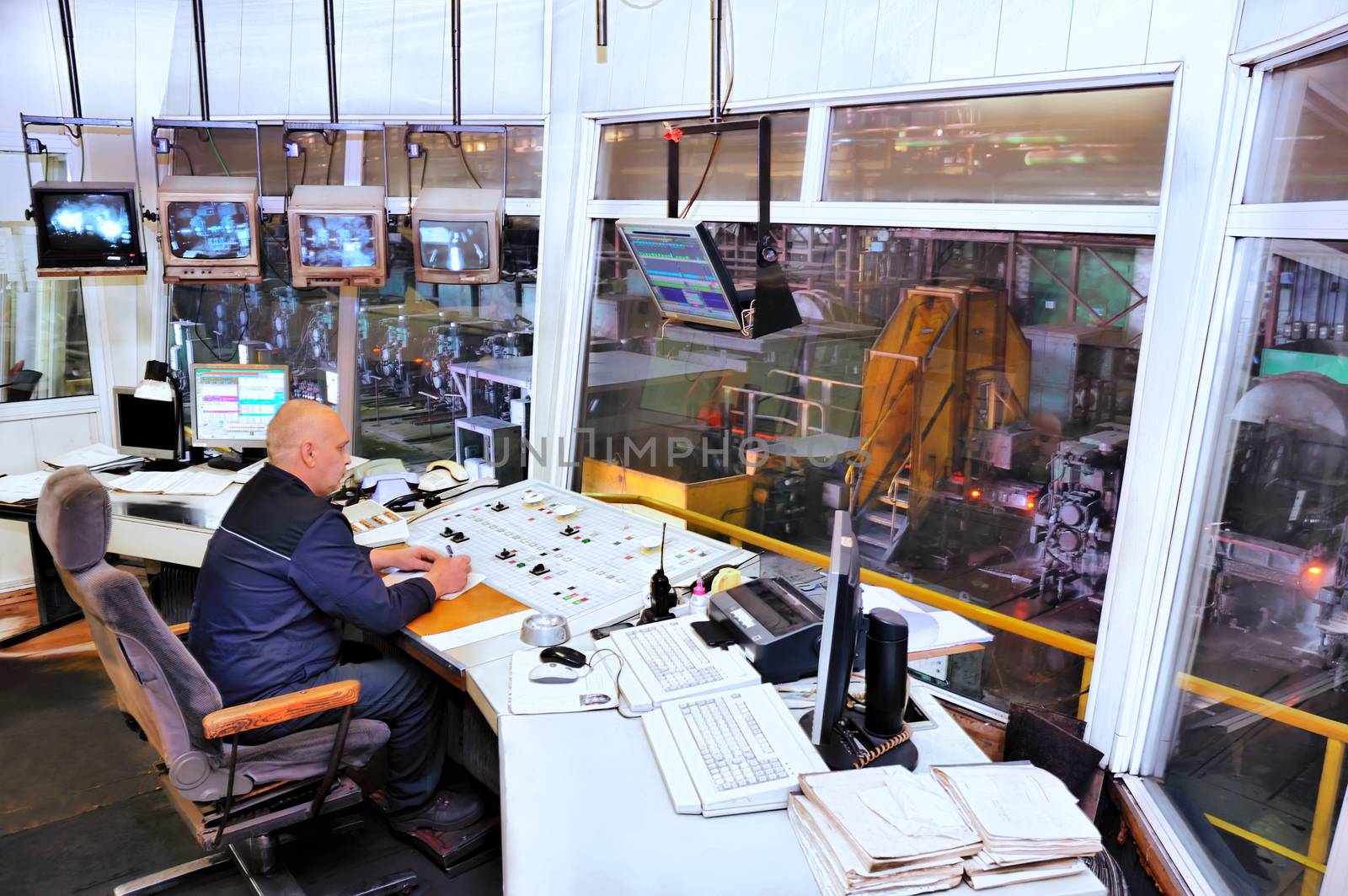 Worker in manufacturing plant at machine control panel