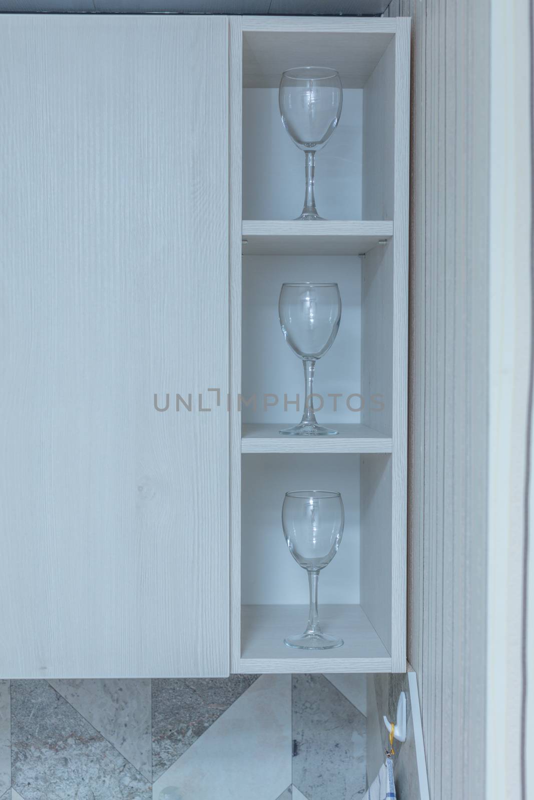 Transparent clean glasses on shelve in open cabinet