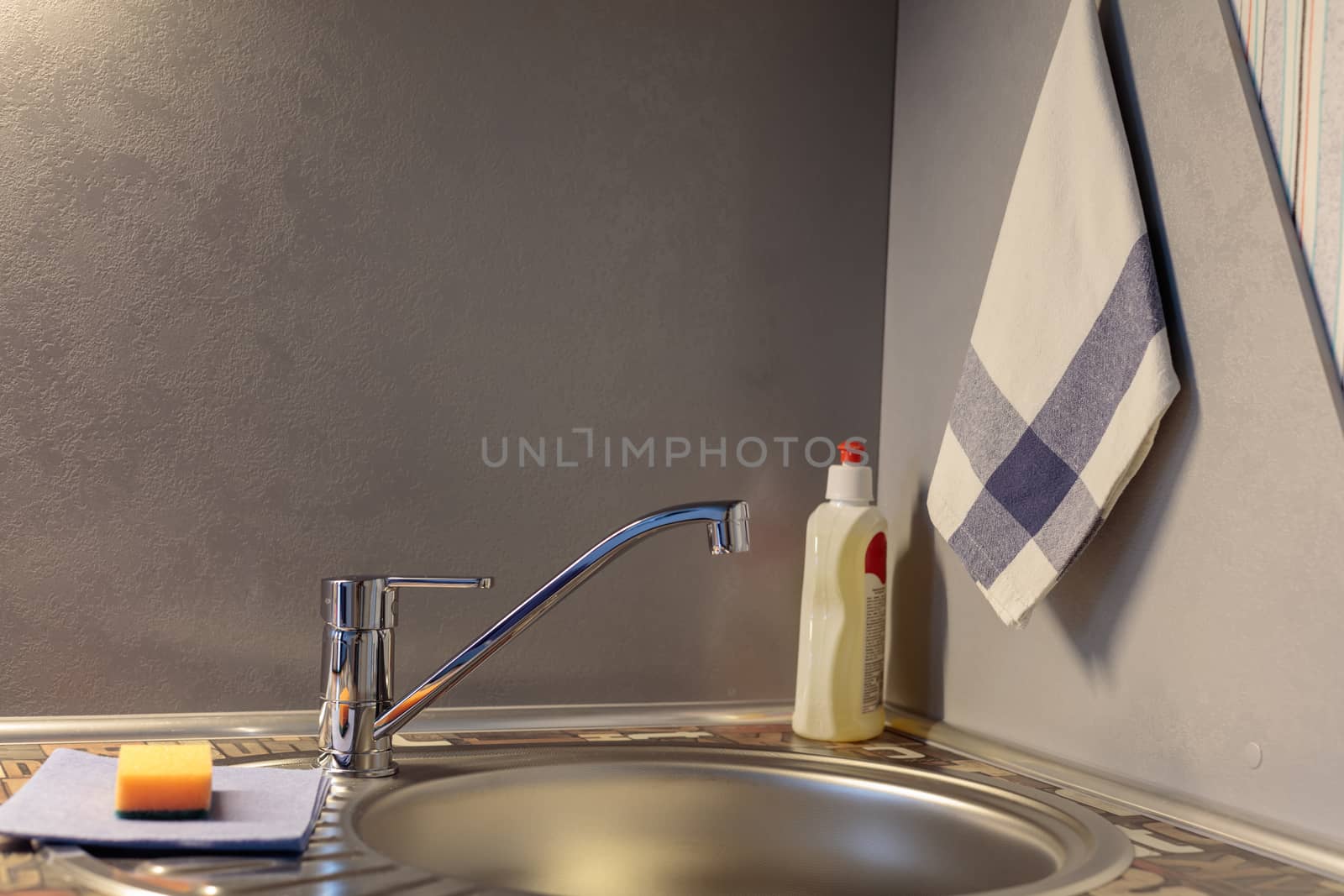 Close up of modern faucet and ceramic sink in kitchen