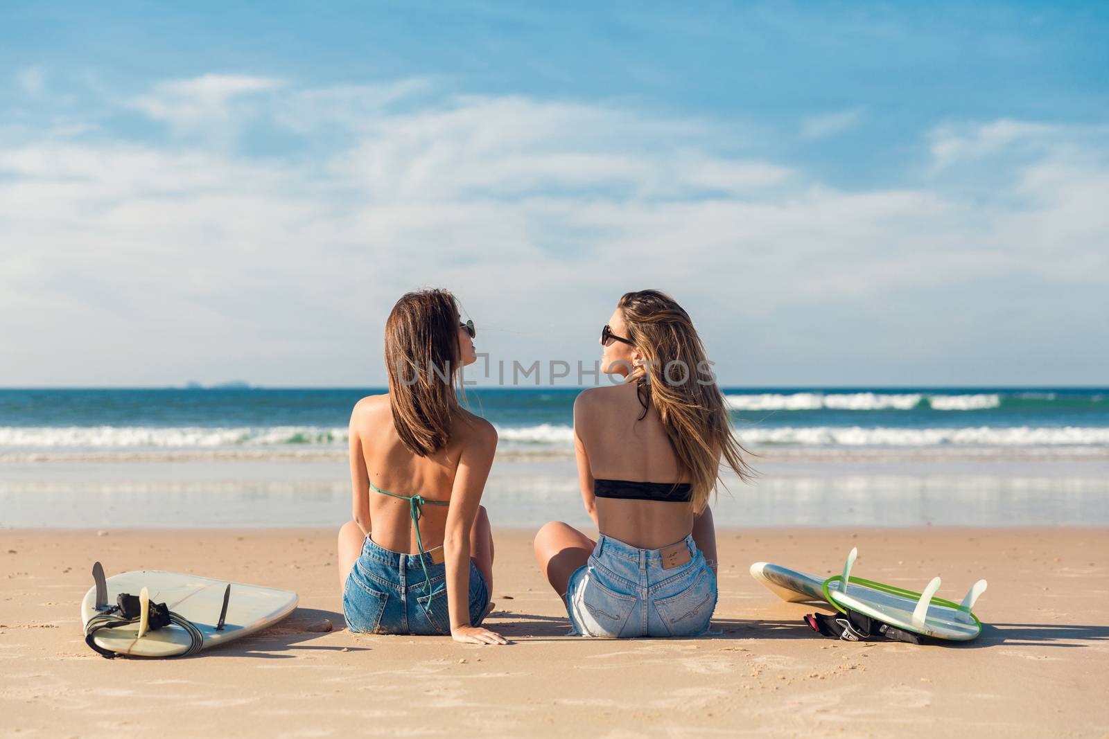 Two surfer girls at the beach by Iko