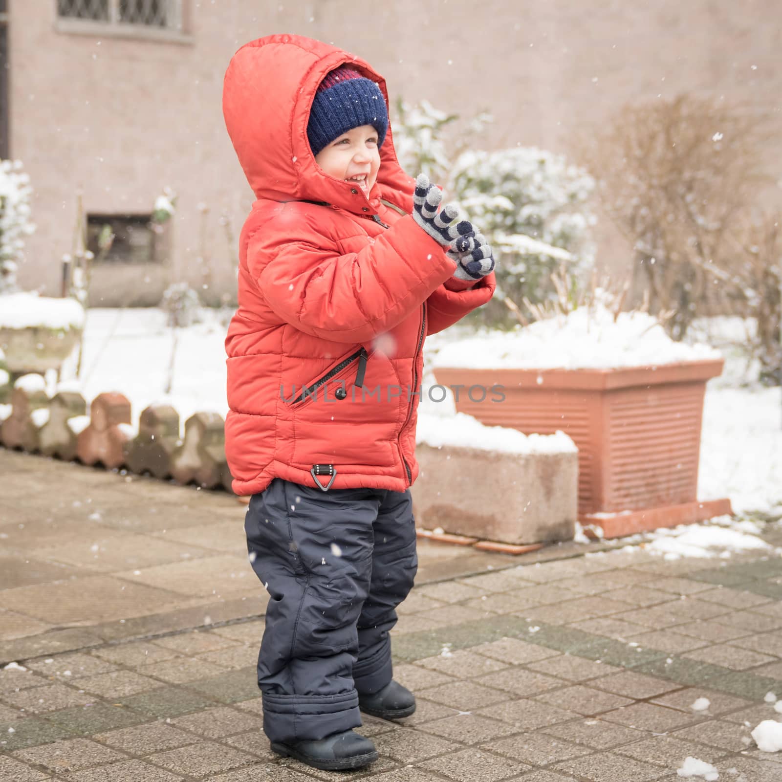 Baby boy smiles cheerfully while snows by Robertobinetti70
