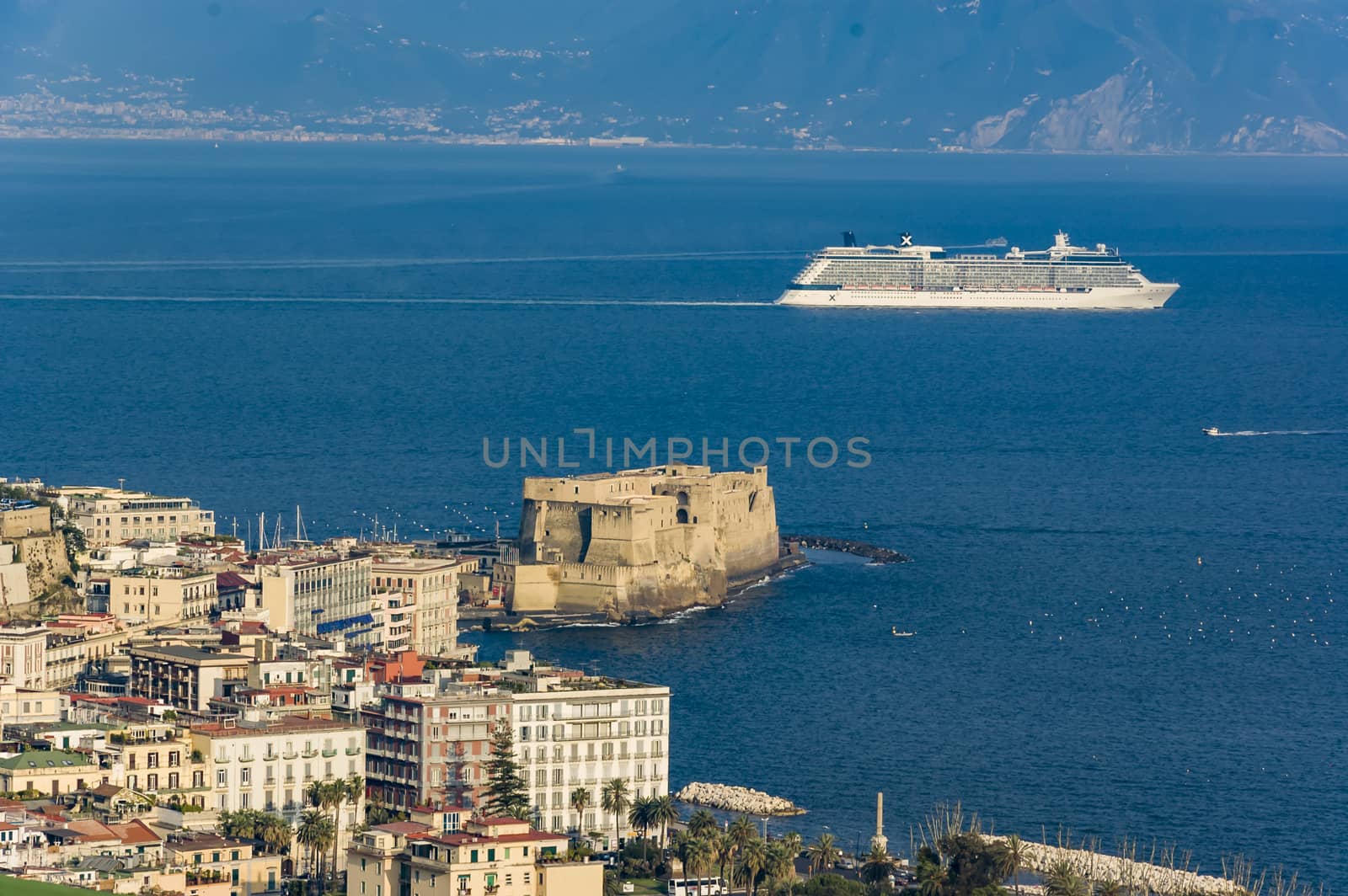 A cruise boat surf in the Bay of Naples with the the view of the castle, Italy