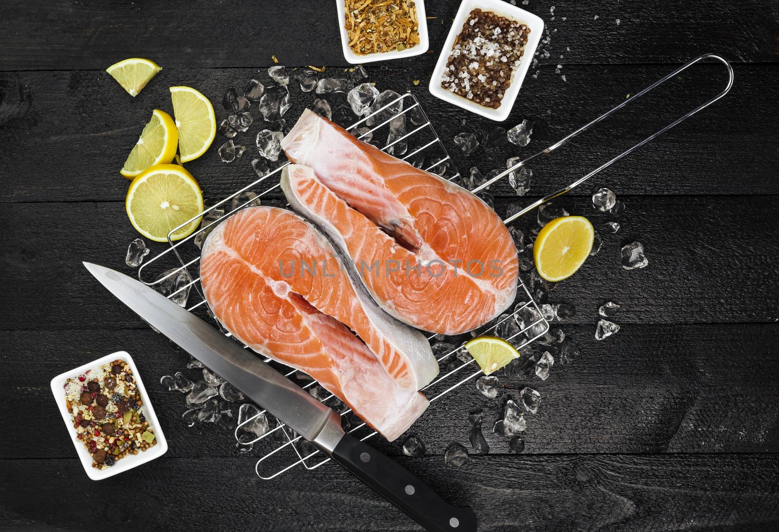 Salmon steak on black wooden table, top view