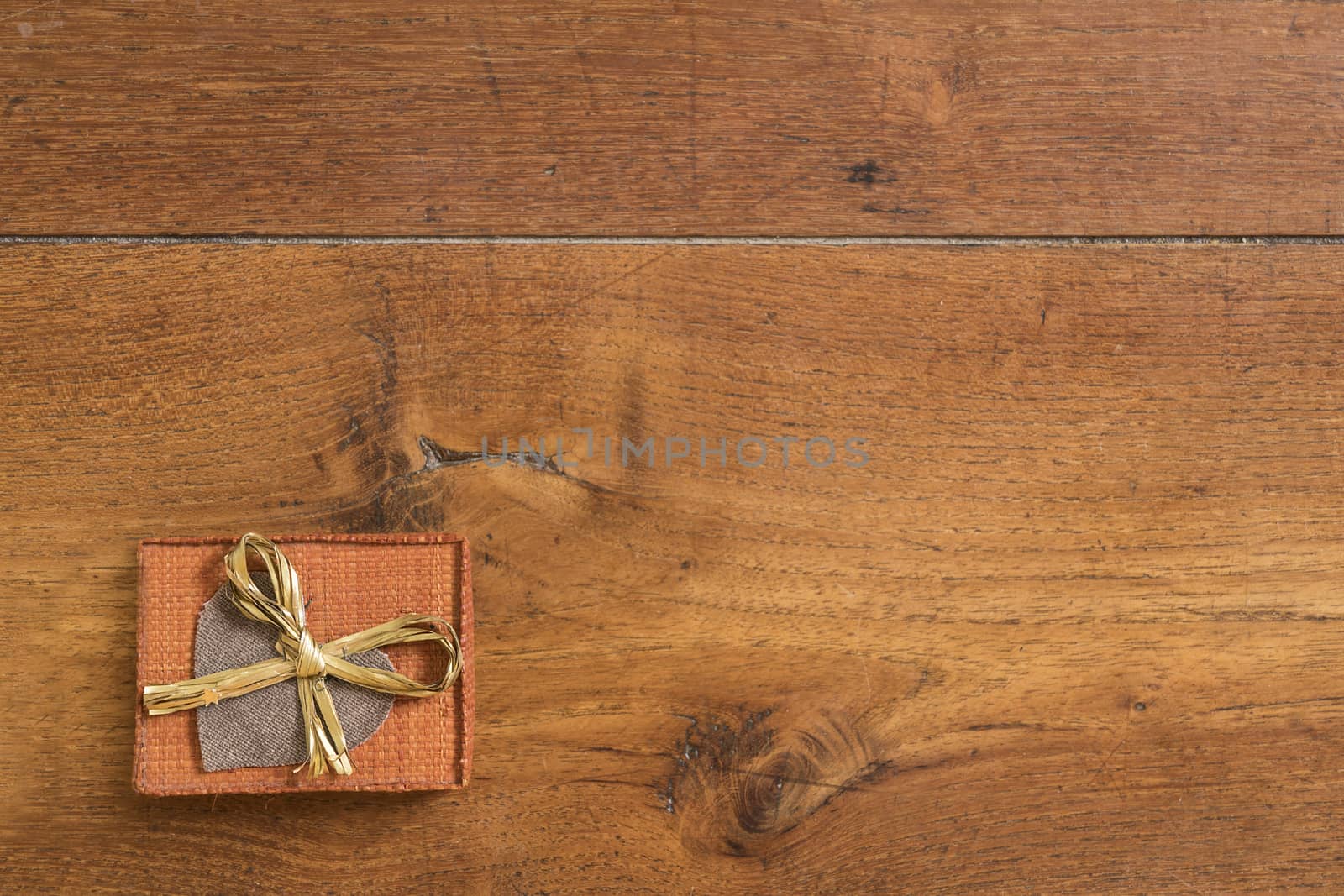 a small package with a heart and a bow on a wooden table