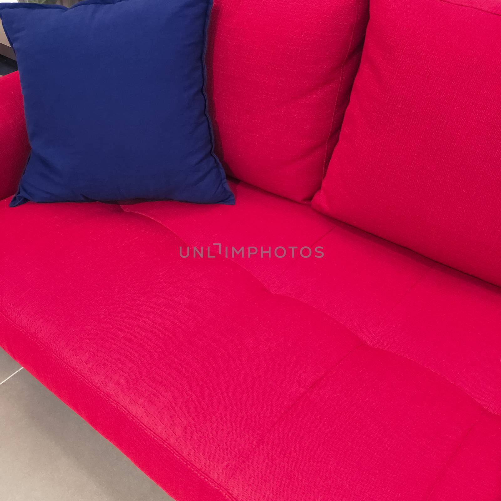 Blue cushion on a red sofa by anikasalsera