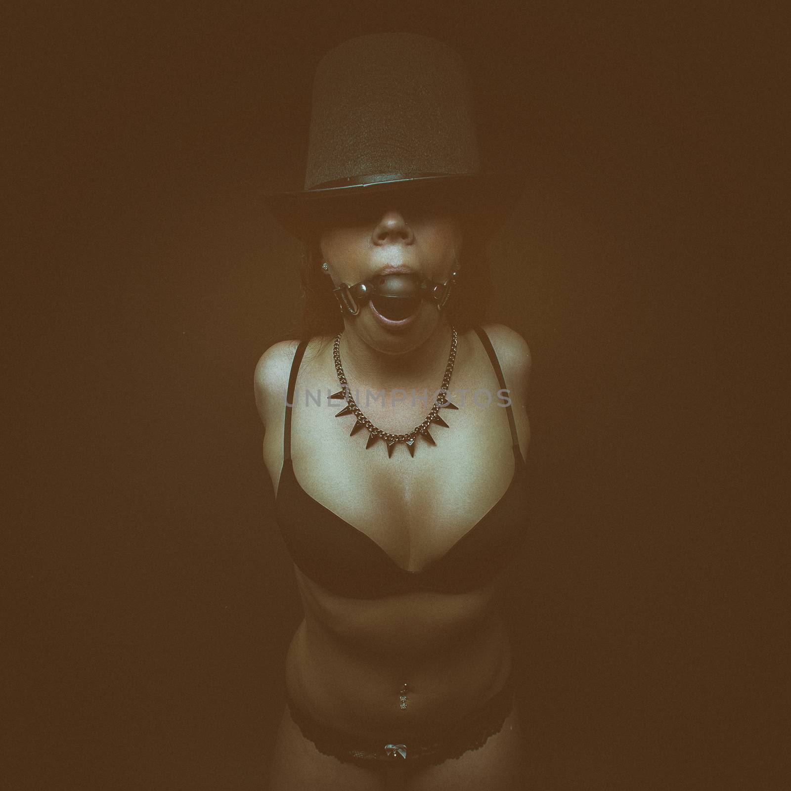 fetish dark portrait glamour girl in hat and bra with gag