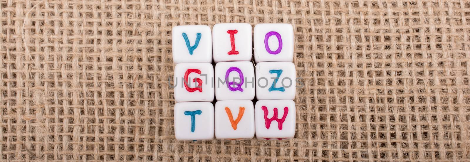 Colorful alphabet letter cubes on a linen canvas