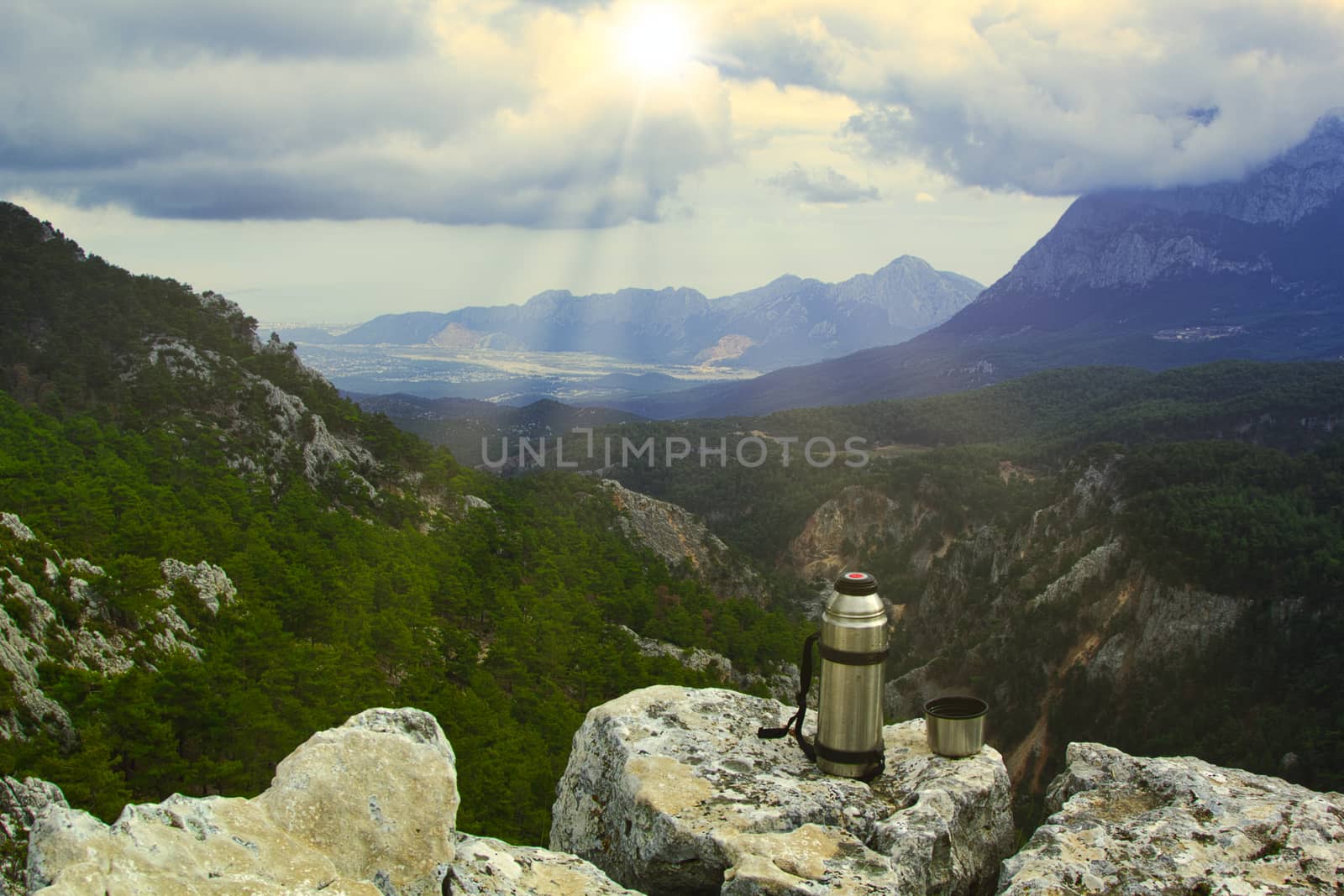 Vintage camera on rock and coffee cup in the morning with mountain view background