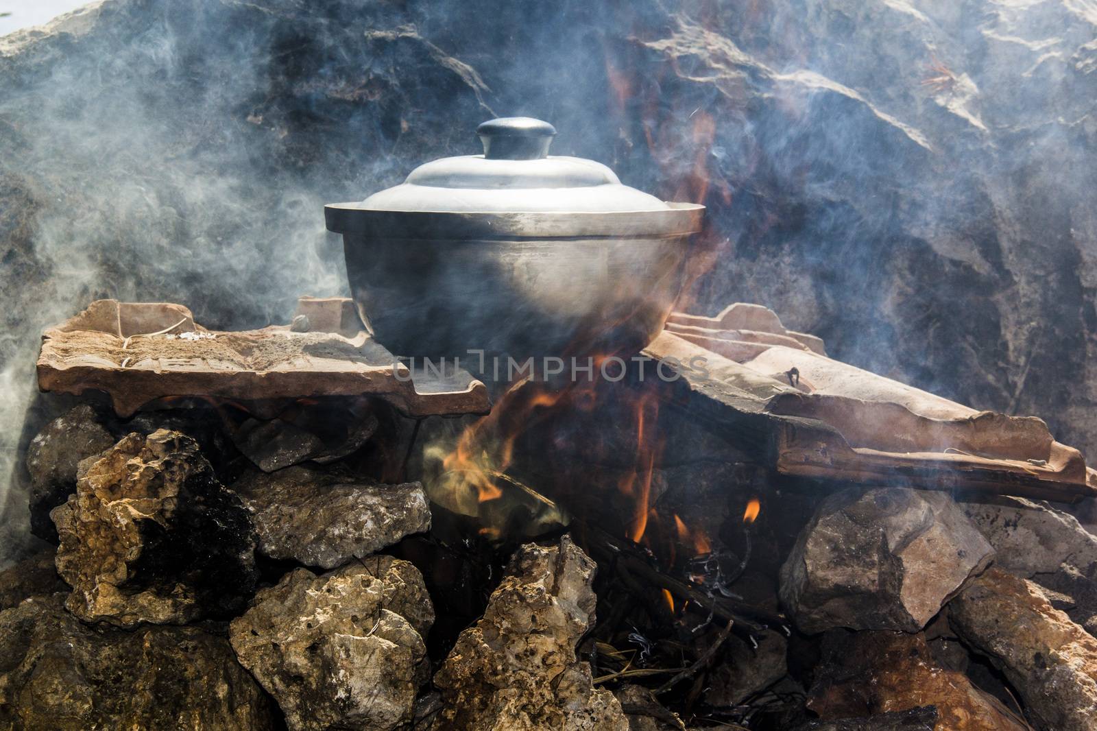 pot of fish soup being prepared on the fire by oaltindag