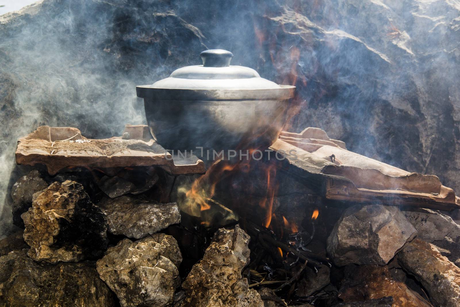 pot of fish soup being prepared on the fire, a warm quiet evening