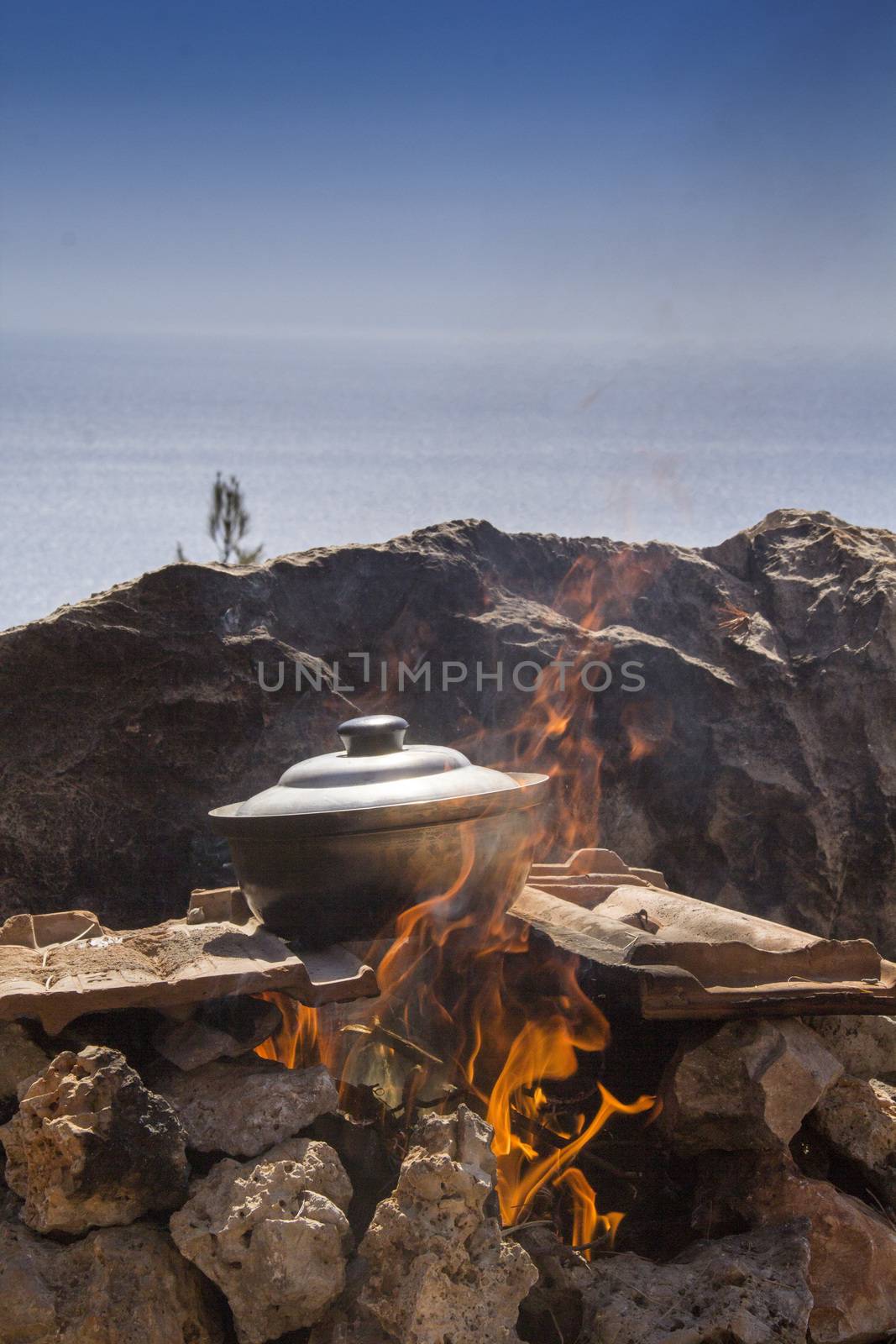 pot of fish soup being prepared on the fire by oaltindag