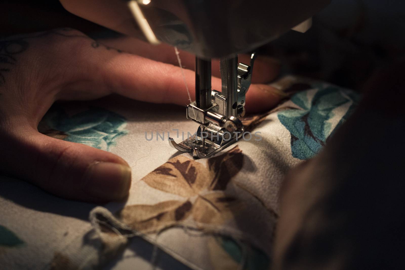 Tailor at Work on Sewing Machine with human hand