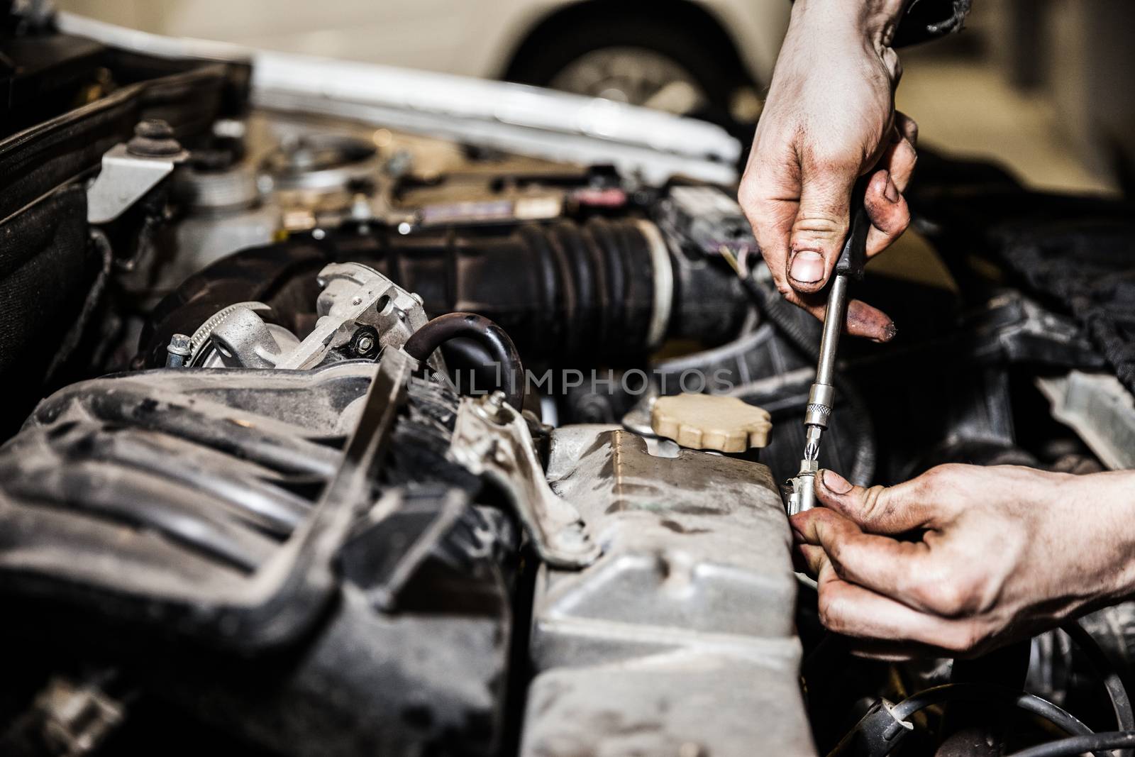 Automobile service worker or garage mechanic repairing auto car engine by ia_64