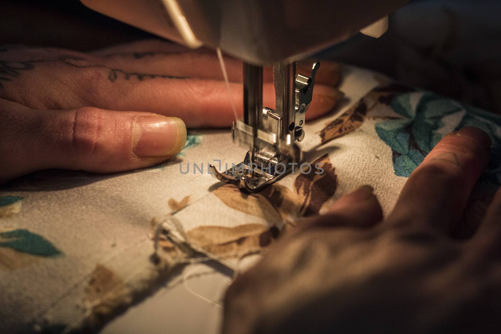 Tailor at Work on Sewing Machine with human hand