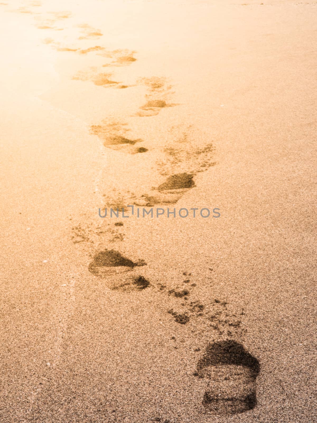 Human shoe prints in a sandy beach.