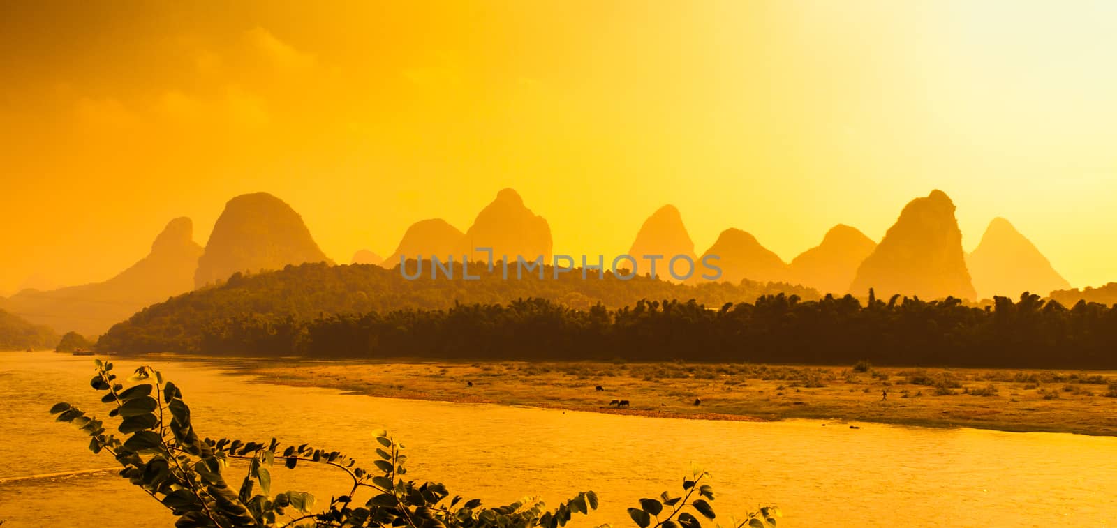 Sunset panorama in karst landscape around Yangshuo an Li River with peaks silhouettes, Guangxi Province, China by pyty