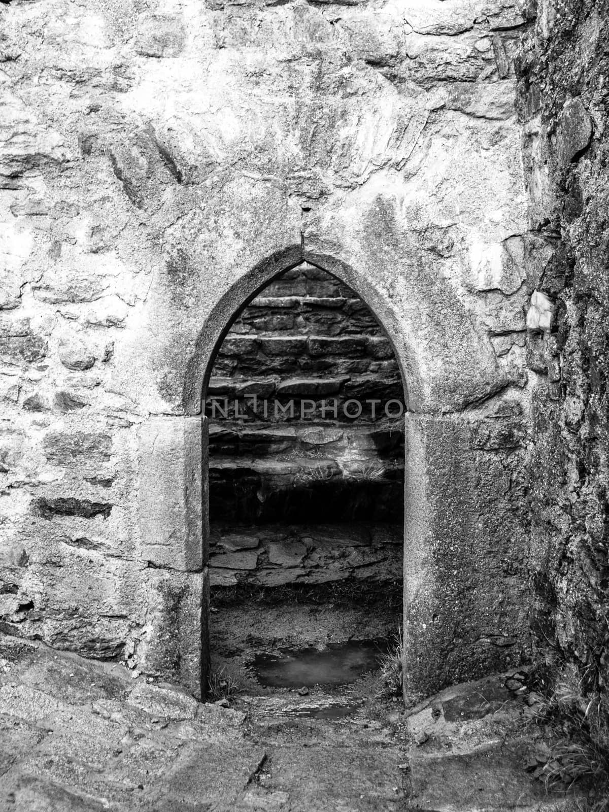 Old gothic arc gate in medieval stone castle ruin by pyty