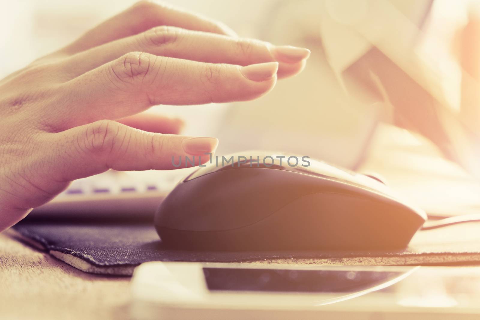 Close-up of female hands using laptop computer, working on laptop with flare light background. Searching Internet ,Businesswoman working at home office