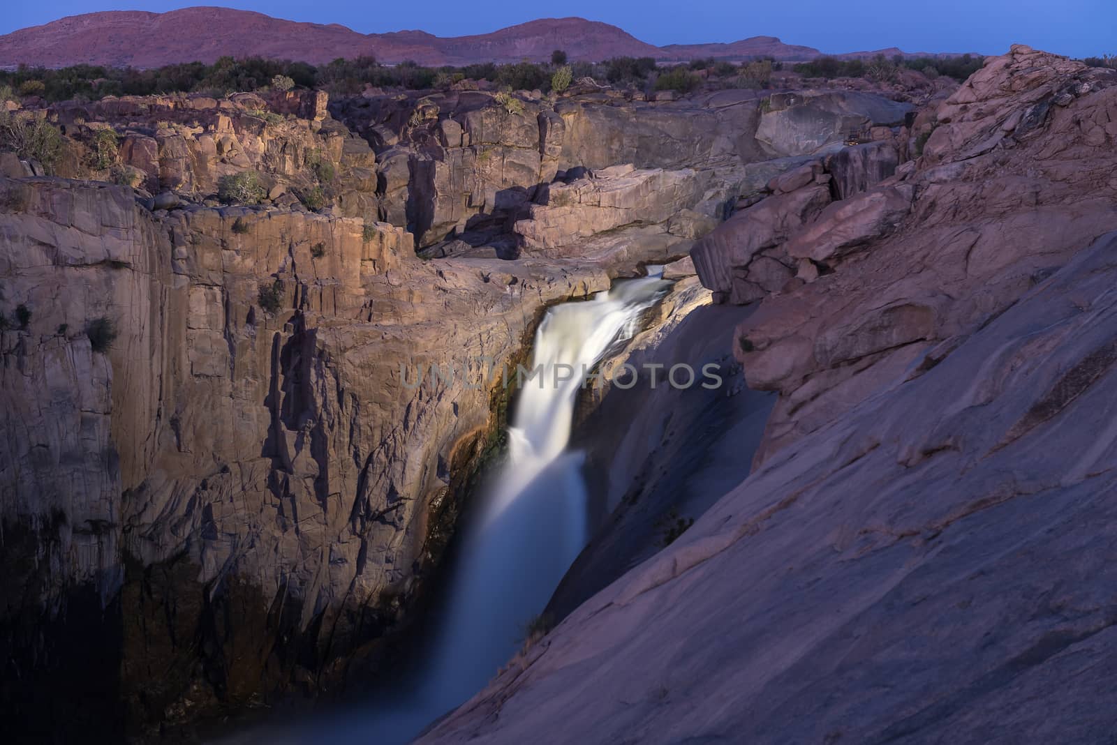 The main Augrabies waterfall after sunset, lighted by a single electric light