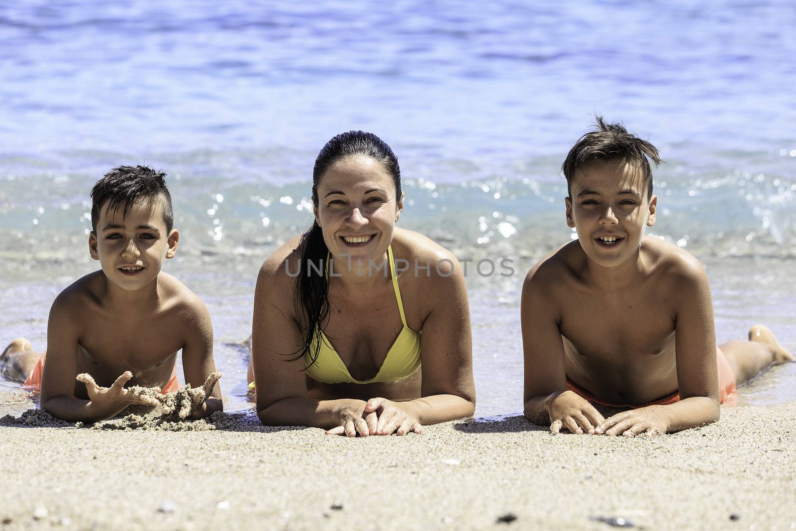 Family mother and her sons on the beach