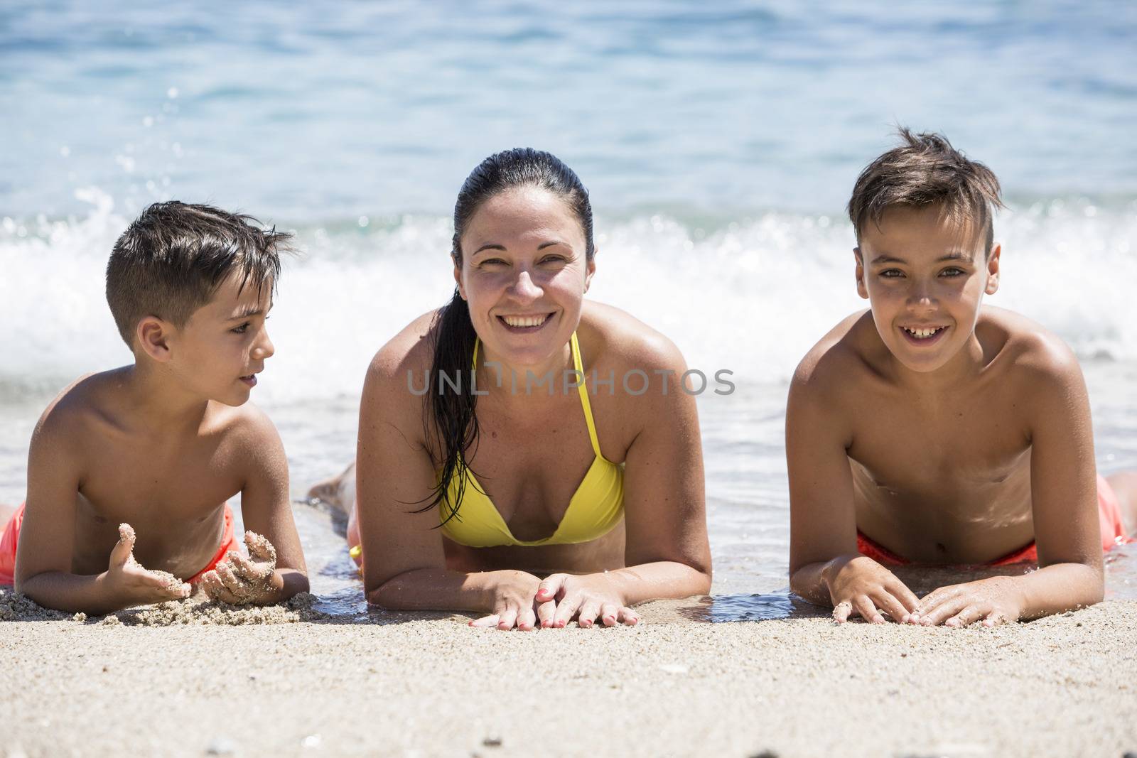 Family mother and her sons on the beach