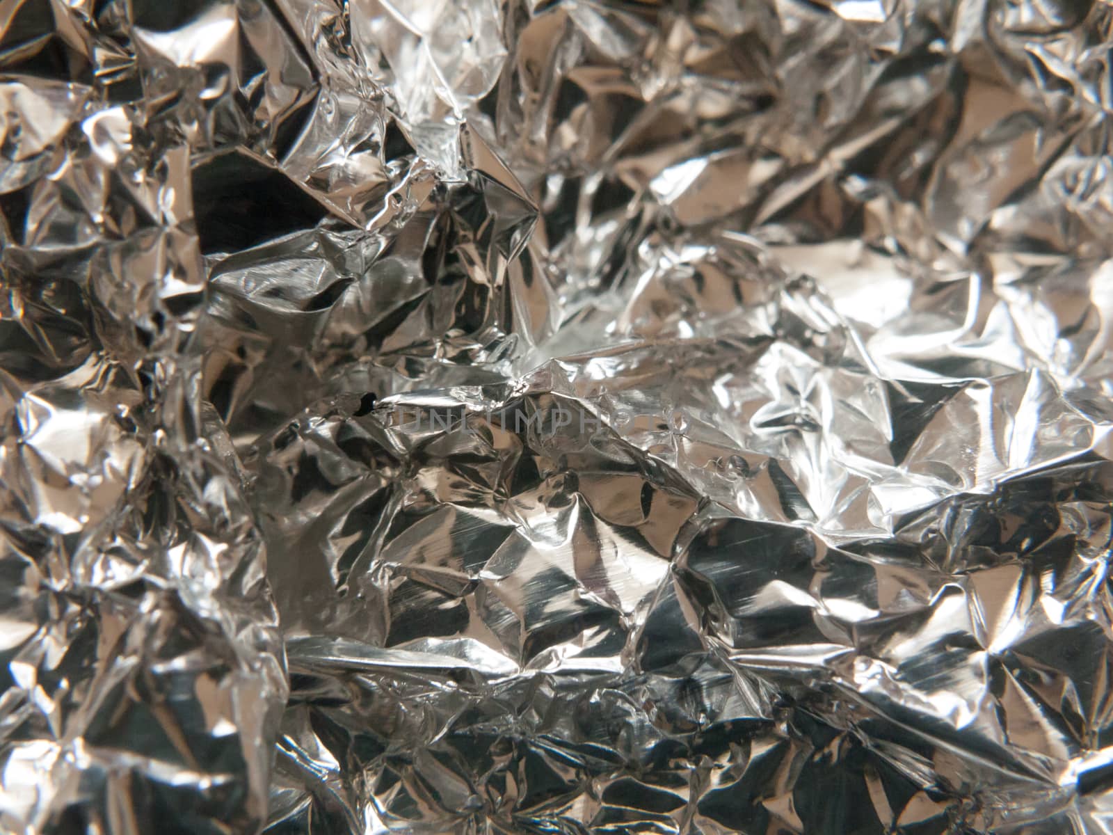 the texture and crinkled pattern of silver aluminium foil; Essex; UK